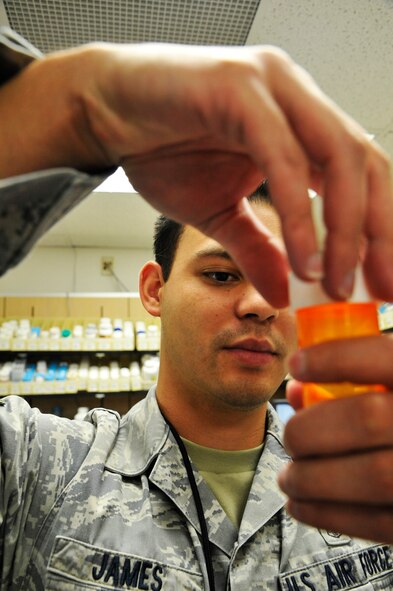 U.S. Air Force Senior Airman Nickolas James, 509th Medical Support Squadron pharmacy technician, caps medication at Whiteman Air Force Base, Mo., June 18, 2014. The childproof safety lids prevent children from gaining access to the medication. (U.S. Air Force photo by Airman 1st Class Keenan Berry/Released)