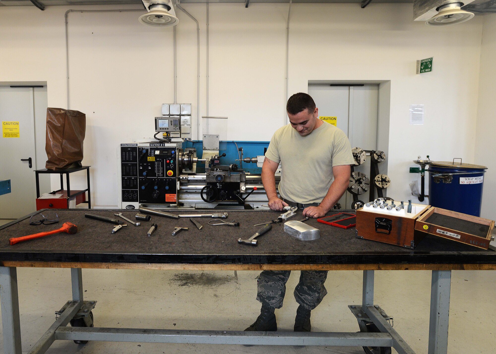 Senior Airman Troy Poe, 31st Maintenance Squadron metals technology journeyman, measures a metal piece, July 9, 2014, at Aviano Air Base, Italy. Fabrication flight is responsible for fashioning tools, aircraft components and other support systems tailored to the F-16 Fighting Falcon. (U.S. Air Force photo/Airman 1st Class Deana Heitzman)