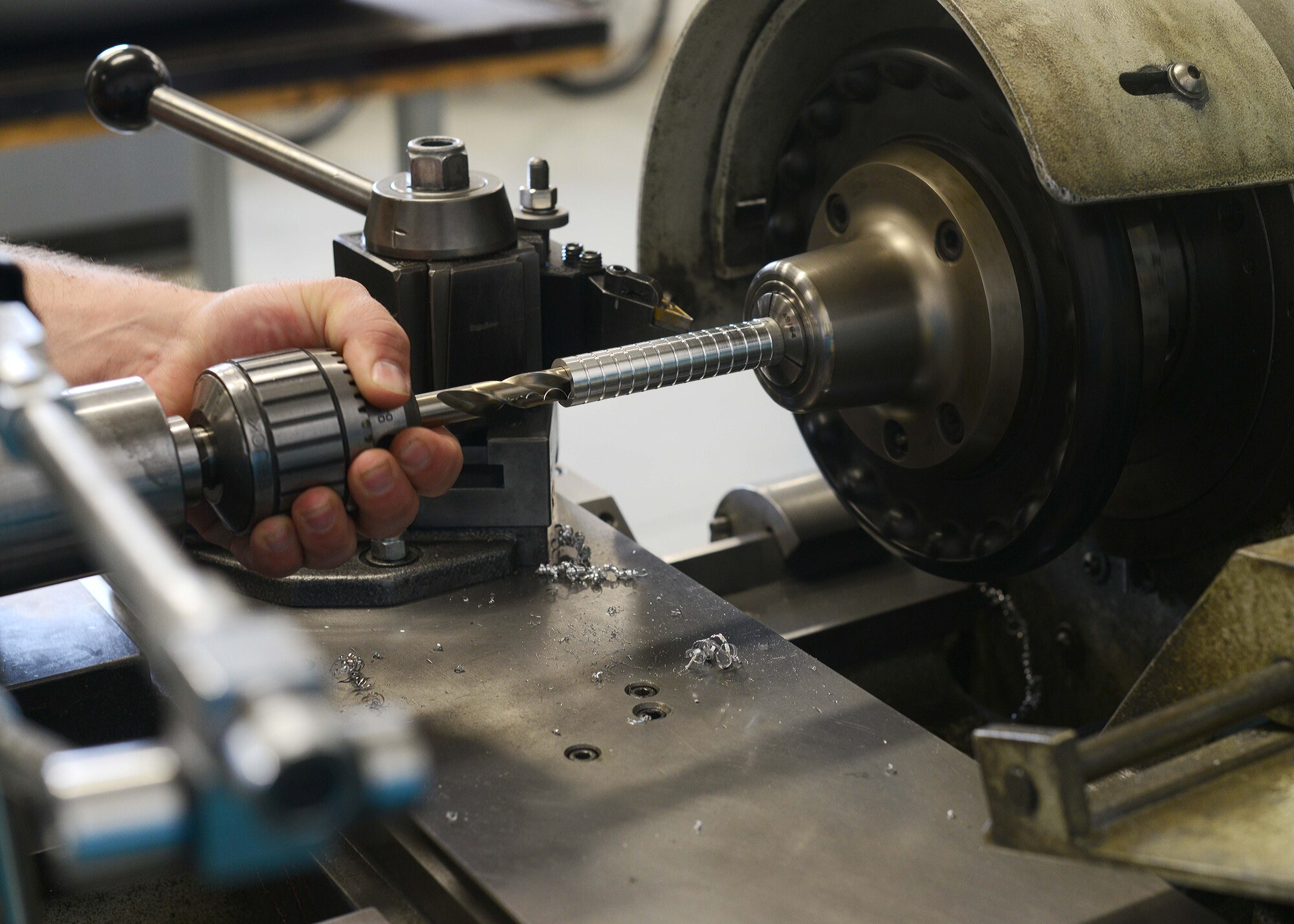 Senior Airman Troy Poe, 31st Maintenance Squadron metals technology journeyman, sands the inside of metal on a lathe, July 9, 2014, at Aviano Air Base, Italy. A lathe is a machine that rotates a piece of metal around an axis of rotation to create bushings for aircraft. (U.S. Air Force photo/Airman 1st Class Deana Heitzman)
