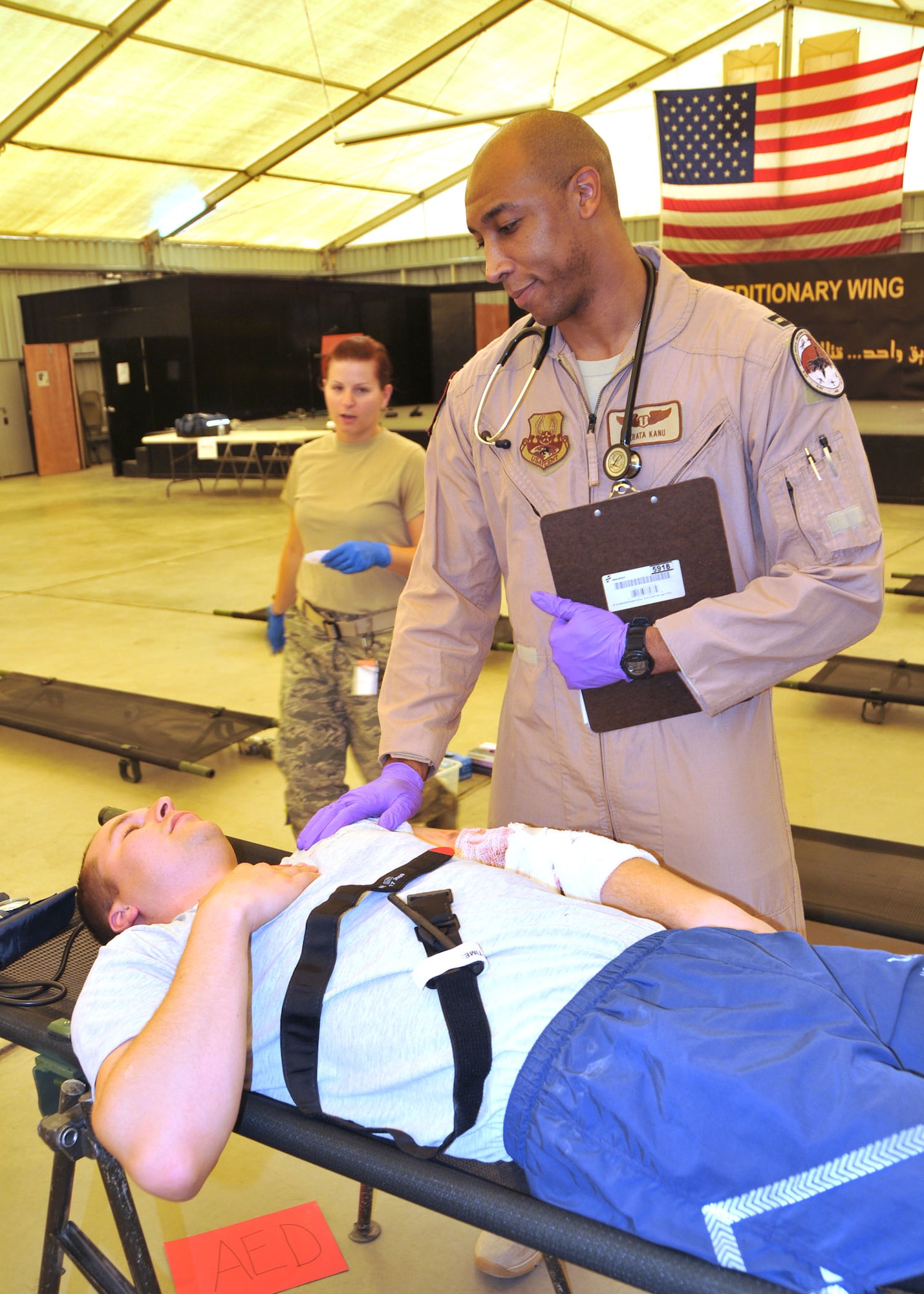 Air Force Capt. Terata Kanu checks the vital signs of Air Force Staff Sgt. Zach Faase during a mass-casualty exercise held in the 380th Air Expeditionary Wing's Phantom Center at an undisclosed location in Southwest Asia, July 13, 2014.  The exercise allowed the members of the 380th Expeditionary Medical Group the chance to practice their medical skills with realistic scenarios.  (U.S. Air Force photo by Senior Master Sgt. Eric Peterson/Released)

