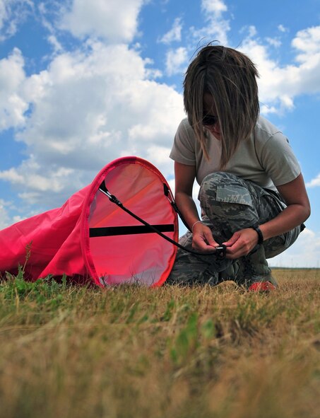 U.S. Air Force Staff Sgt. Alexis Effinger-Morris, 435th Aircraft Maintenance Squadron contingency airfield manager, places a visual airfield marking panel in preparation for land zone training held at Powidz Air Base, Poland, July 11, 2014. Airmen from the 86th Airlift Wing are training in Eastern Europe to help strengthen partnerships within the Baltic areas while training jointly with our sister services. (U.S. Air Force photo by Senior Airman Christine Griffiths/Released)