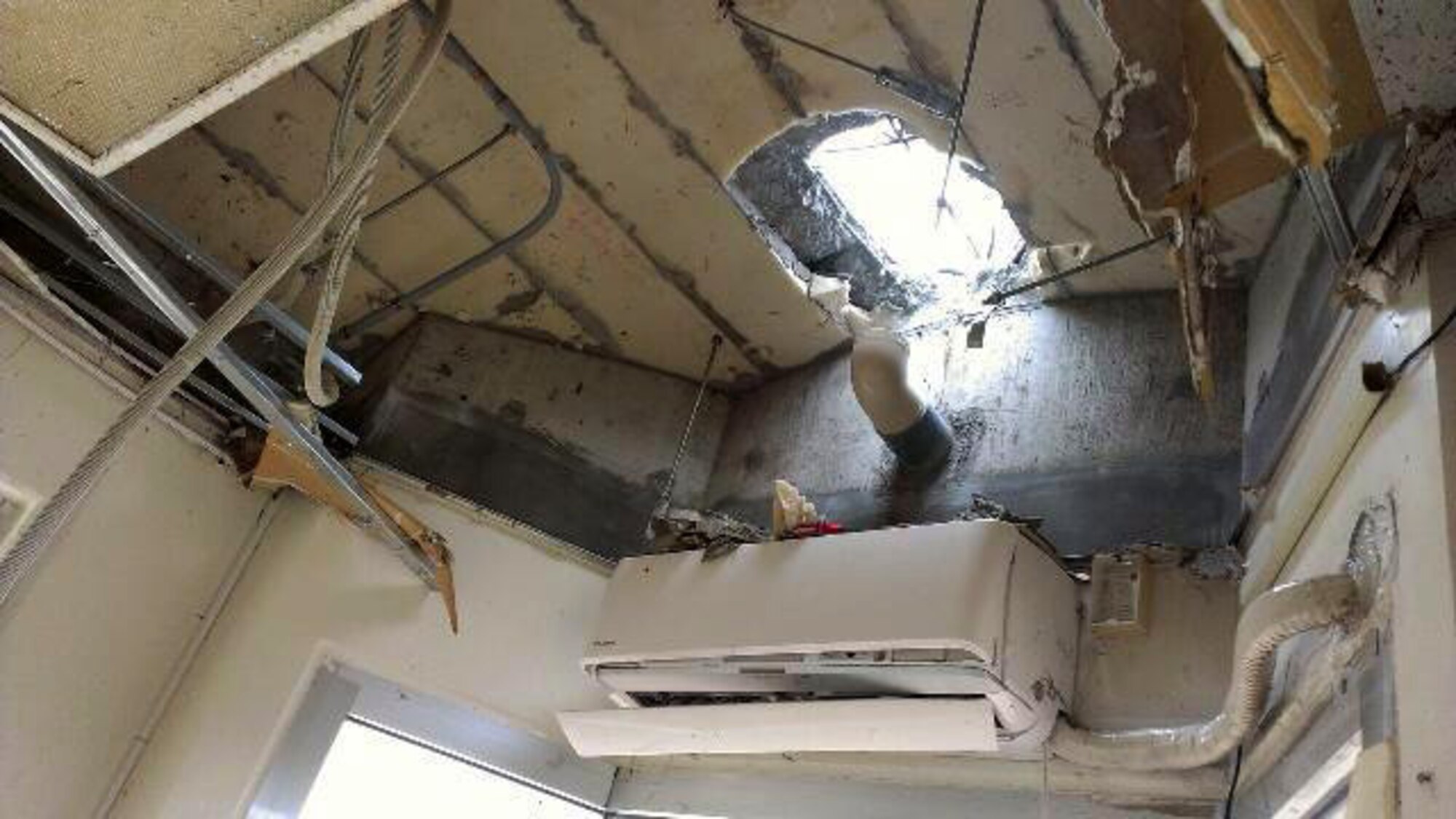 First responders worked as a team to rescue two U.S. Air Force Airmen trapped inside a flooded guard shack on Kadena Air Base, Japan, July 9, 2014. The responders were able to successfully cut a hole in the guard shack and free the airmen by using tools such as sledge hammers, axes and k-12 fire rescue saws. (Courtesy photo)