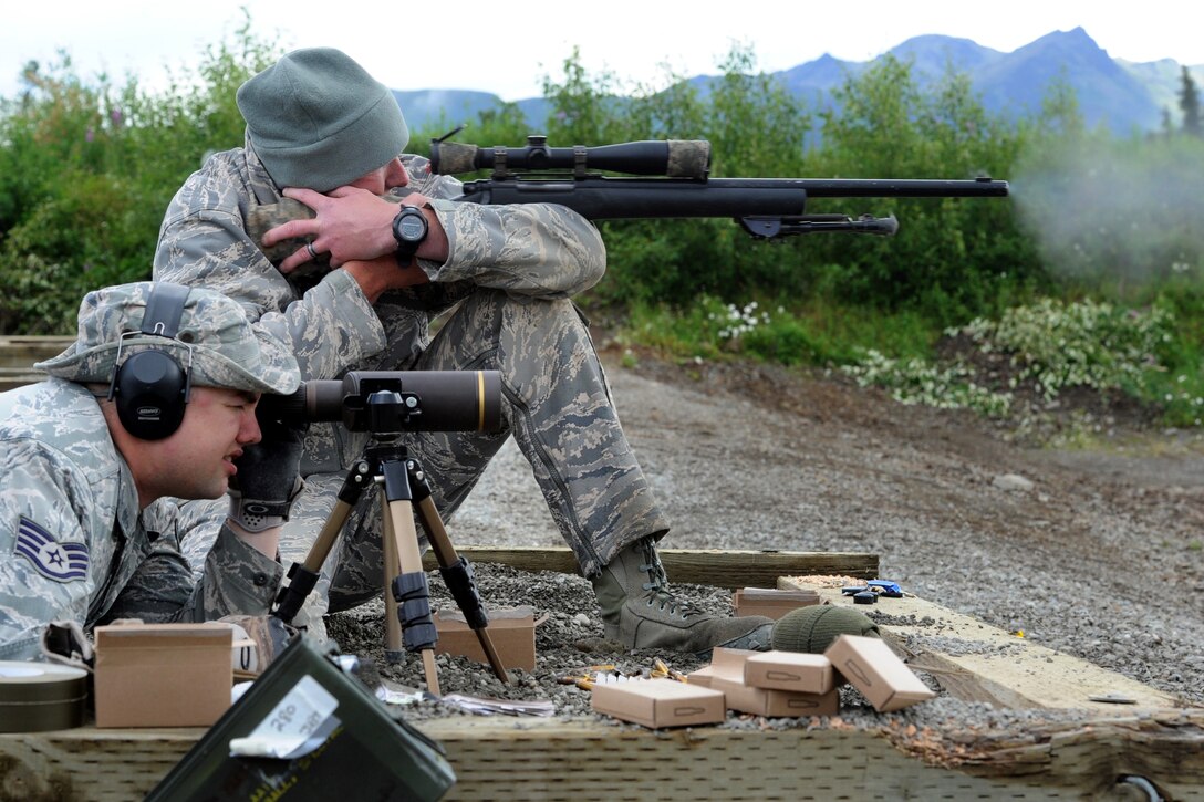 Air Force Staff Sgt. Ryan Link, foreground, uses a spotting scope as Air Force Tech. Sgt. Jerimiah Brock engages targets while firing his M24 Sniper Weapon System on Joint Base Elmendorf-Richardson, Alaska, July 11, 2014. Link and Brock are assigned to the 673rd Security Forces Squadron.