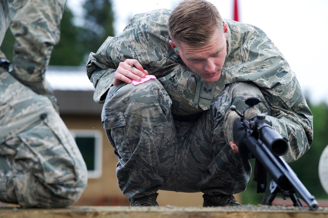 Air Force Senior Airman Aric Shott inspects the scope of a M24 Sniper Weapon System on Joint Base Elmendorf-Richardson, Alaska, July 11, 2014. Shott is assigned to the 673rd Security Forces Squadron.