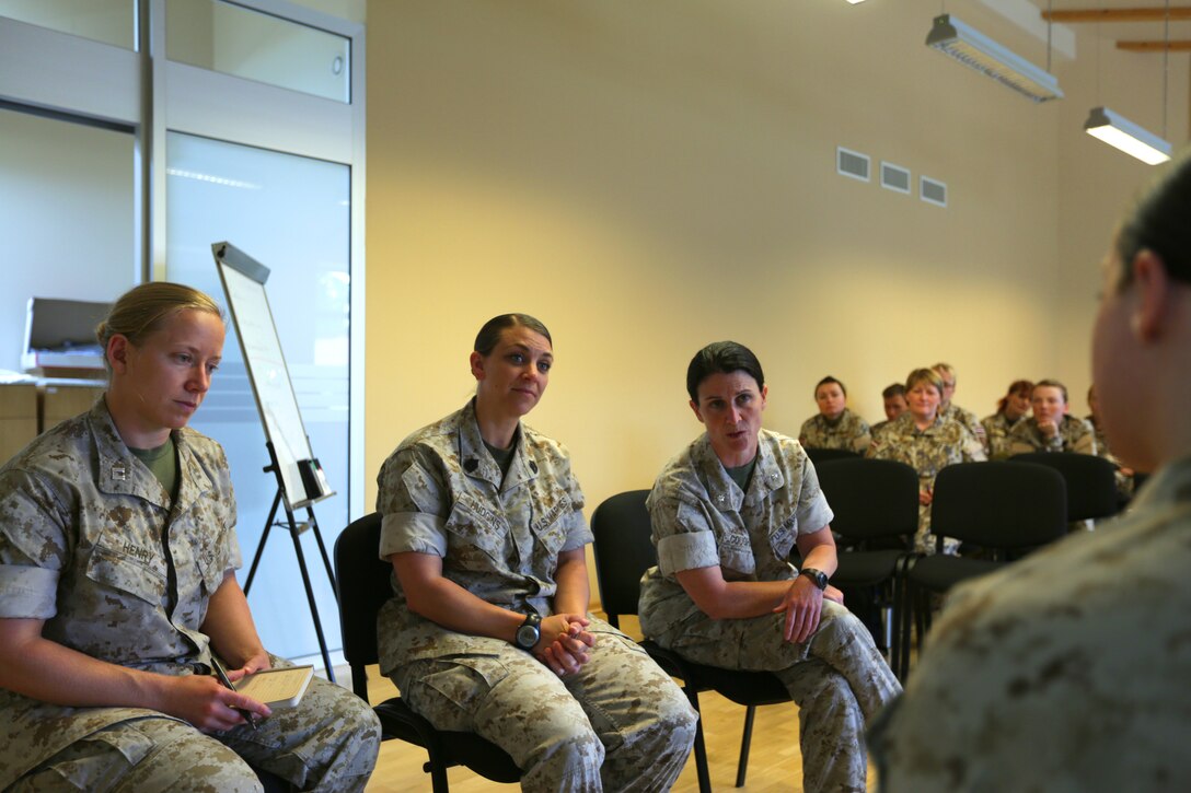 In front of Latvian Armed Forces soldiers being introduced Female Engagement Team concepts, U.S. Marines from Marine Forces Europe and Africa demonstrate an interview and negotiation scenario before a practical application exercise. U.S. Marines introduced Female Engagement Team concepts to a group of Latvian servicemembers from June 17-19 at Adazi Military Base, Latvia; this introduction was the first step for the Baltic partner to further evaluate the capability for use within their own military.