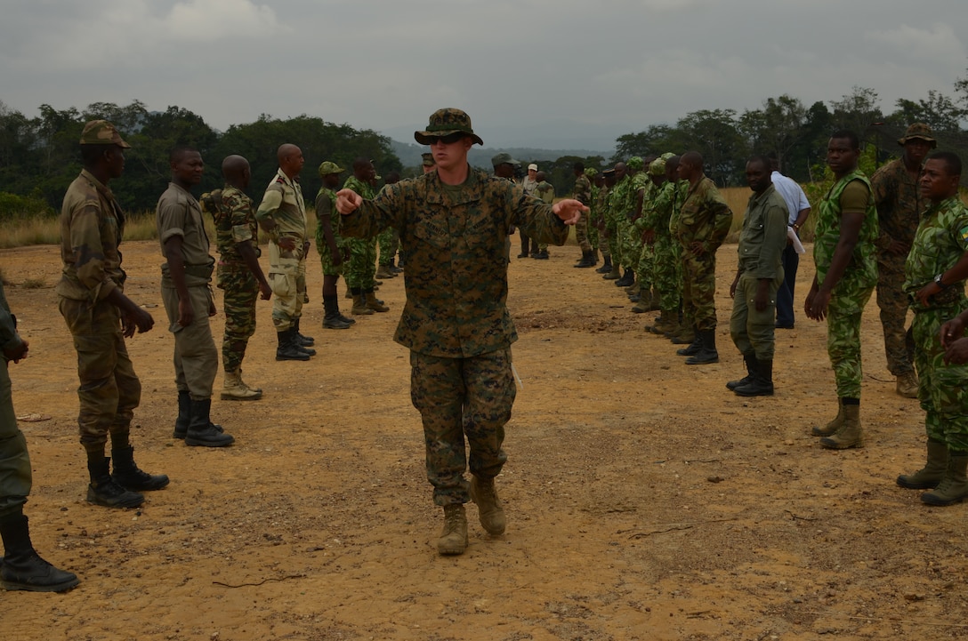 Corporal Michael Kennedy, a Marine with Special-Purpose Marine Air-Ground Task Force Africa 14, discusses detainee handling with members of a task force in Gabon, June 10, 2014. A team of 15 Marines and sailors trained with their Gabonese counterparts from the Agence Nationale des Parcs Nationaux and the Gabonese military and Gendarmerie to demonstrate tactics that could then be applied to combat all types of illicit activities, to include narcotics trafficking.