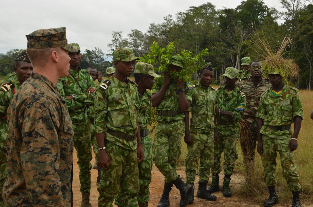 Lance Cpl. Spencer Ray, a Marine with Special-Purpose Marine Air-Ground Task Force Africa 14, discusses cover and concealment with members of a task force in Gabon, June 3, 2014. A team of 15 Marines and sailors trained with their Gabonese counterparts from the Agence Nationale des Parcs Nationaux and the Gabonese military and Gendarmerie to demonstrate tactics that could then be applied to combat all types of illicit activities, to include narcotics trafficking.