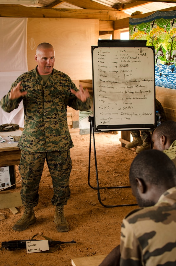 Captain Peter Driscoll, the team leader for a theater security cooperation team with Special-Purpose Marine Air-Ground Task Force Africa 14, discusses tactical site exploitation with members of a task force in Gabon, June 13, 2014. A team of 15 Marines and sailors trained with their Gabonese counterparts from the Agence Nationale des Parcs Nationaux and the Gabonese military and Gendarmerie to demonstrate tactics that could then be applied to combat all types of illicit activities, to include narcotics trafficking.
