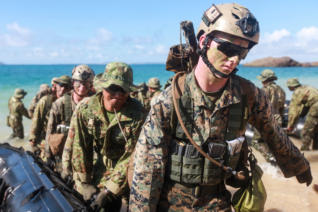 Soldiers with the Japan Ground Self Defense and U.S. Marines and sailors carry combat rubber raiding crafts ashore during boat operations as part of the Japan Observer Exchange Program at Kin Blue beach here, July 16. The soldiers are with JGSDF’s Western Army and the Marines and sailors are with Company L, Battalion Landing Team 3rd Battalion, 5th Marines, 31st Marine Expeditionary Unit. The JGSDF soldiers have been observing L Co. for approximately six weeks. JOEP enables the JGSDF observation and education of small unit concepts, tactics, and amphibious operations to further enhance the interoperability of the two forces and security of the region.