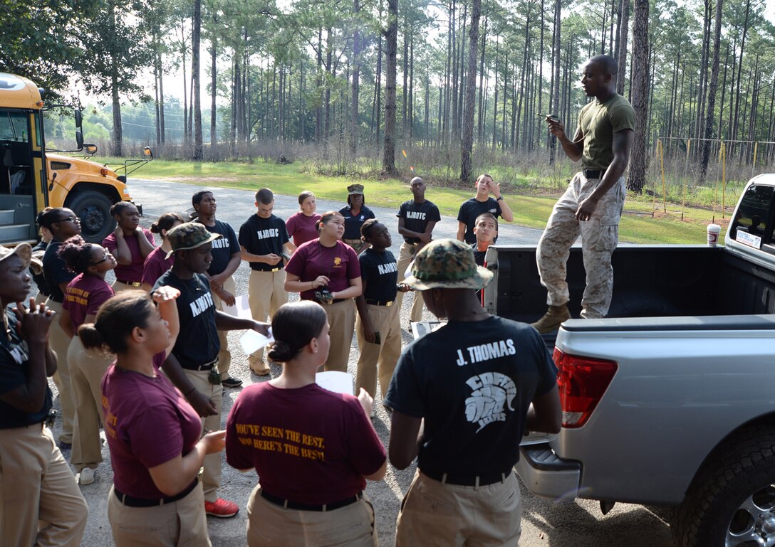 Sgt. Aspen Thompson, distant professional military education program manager, Base Operations, Marine Corps Logistics Base Albany, demonstrates the proper use of a compass for Coffee County High School Navy Junior Reserve Officer Training Corps cadets July 11 at MCLB Albany. 