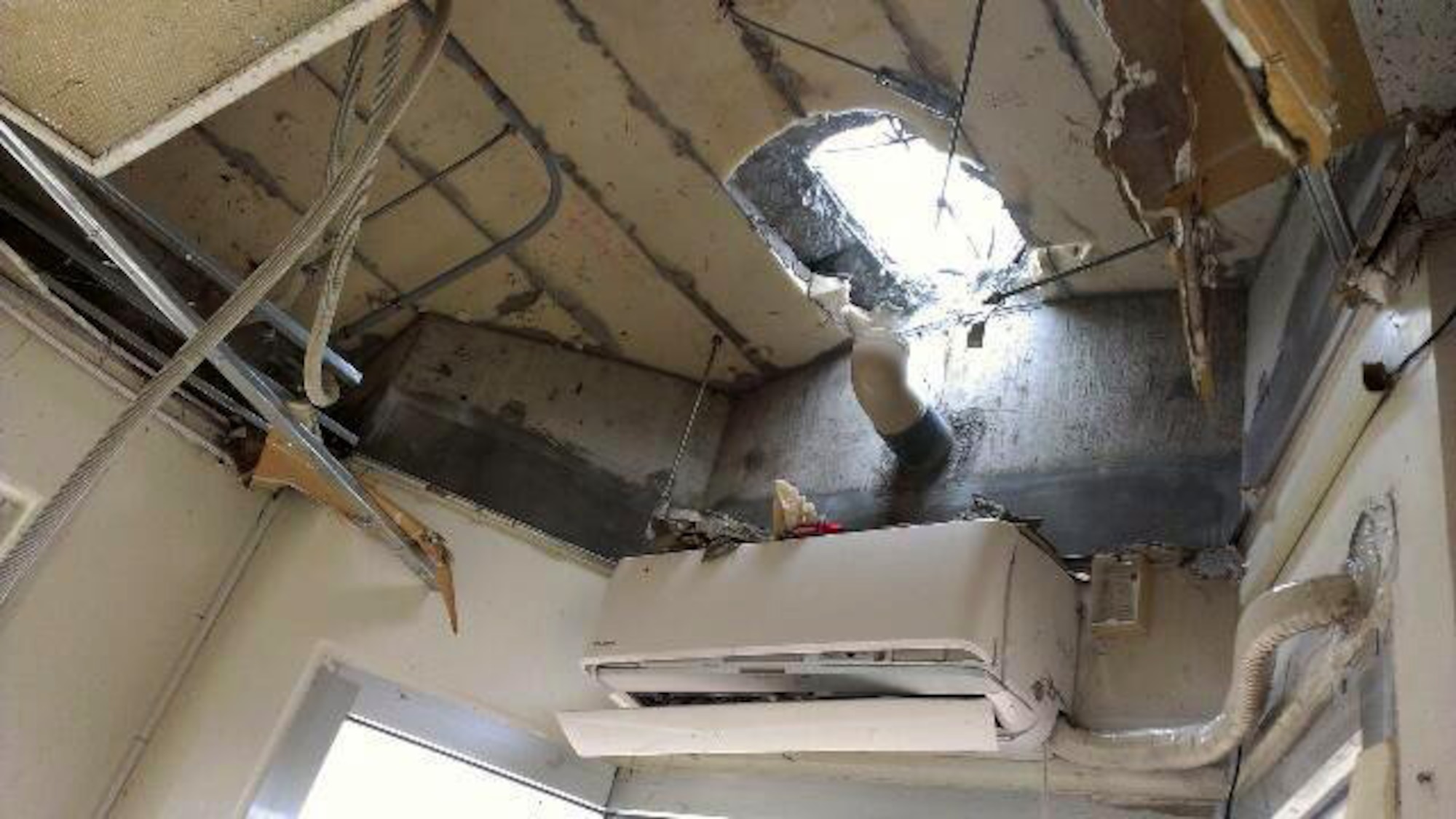 The hole cut by the team of first responders that rescued two Airmen trapped inside a flooded guard shack July 9, 2014 on Kadena Air Base, Japan. The Airmen were trapped in the shack by a flash flood caused by Neoguri, a category 4 typhoon, which struck the western coast of Okinawa, Japan, July 7-9. The responders were able to successfully cut a hole in the guard shack and free the airmen by using sledge hammers, axes and k-12 fire rescue saws. (Courtesy photo)