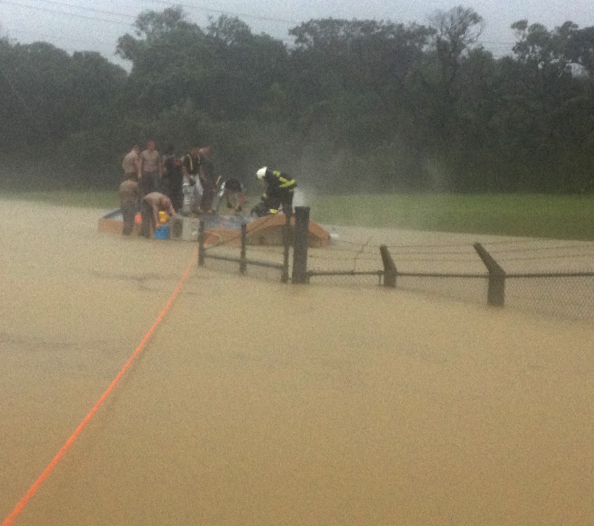 A team of first responders work to cut a hole in the roof of a flooded guard shack to rescue two Airmen trapped inside July 9, 2014, on Kadena Air Base, Japan. The flash flood was caused by Neoguri, a category 4 typhoon, which struck the western coast of Okinawa, Japan, July 7-9. Due to the efforts of the responders the Airmen were rescued safely. (Courtesy photo)