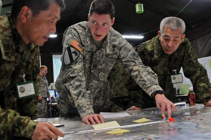 Army Capt. Jeremy Lyon, an infantry officer with the Wisconsin Army National Guard's 332nd Rear Operations Center, discusses troop movements with his Japanese counterparts at Camp Itami, Japan, Feb. 4, 2012. Lyon is participating in Yama Sakura 61, which was held just north of Osaka. Yama Sakura is an annual Japan-based, simulation-driven, joint-bilateral command post exercise held with the Japanese Ground Self-Defense Force and the U.S. military, designed to enhance U.S. and Japan combat readiness and interoperability and strengthen military relationships.