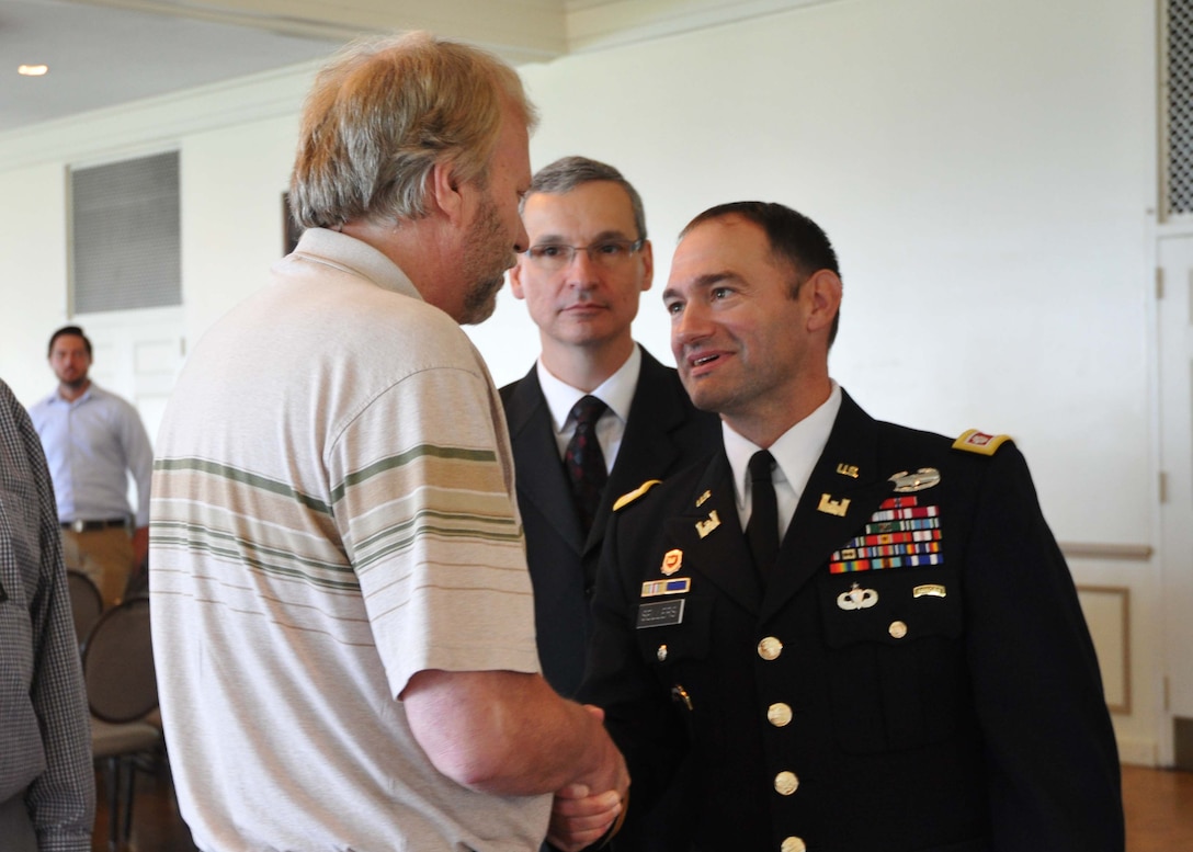 Jeff Follett, a project manager, welcomes Lt. Col. Michael L. Sellers who took command that day of the Detroit District during the change of command ceremony July 10, 2014.