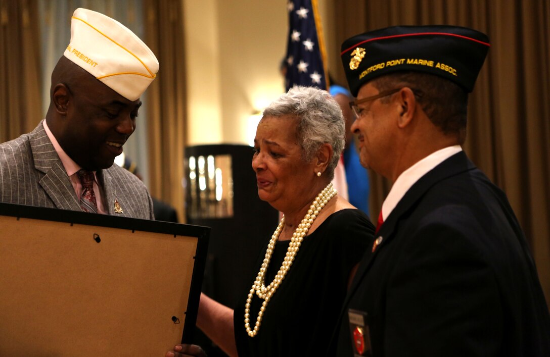 Gladys Allen-Smith accepts the Congressional Gold Medal on behalf of her late father Charles E. Allen at the National Montford Point Marine Association’s 49th Annual National Convention, July 16, 2014. Allen was one of the original Montford Point Marines. The president and vice president of the National Montford Point Marine Association presented the medal to Allen-Smith during the National President’s Reception.  