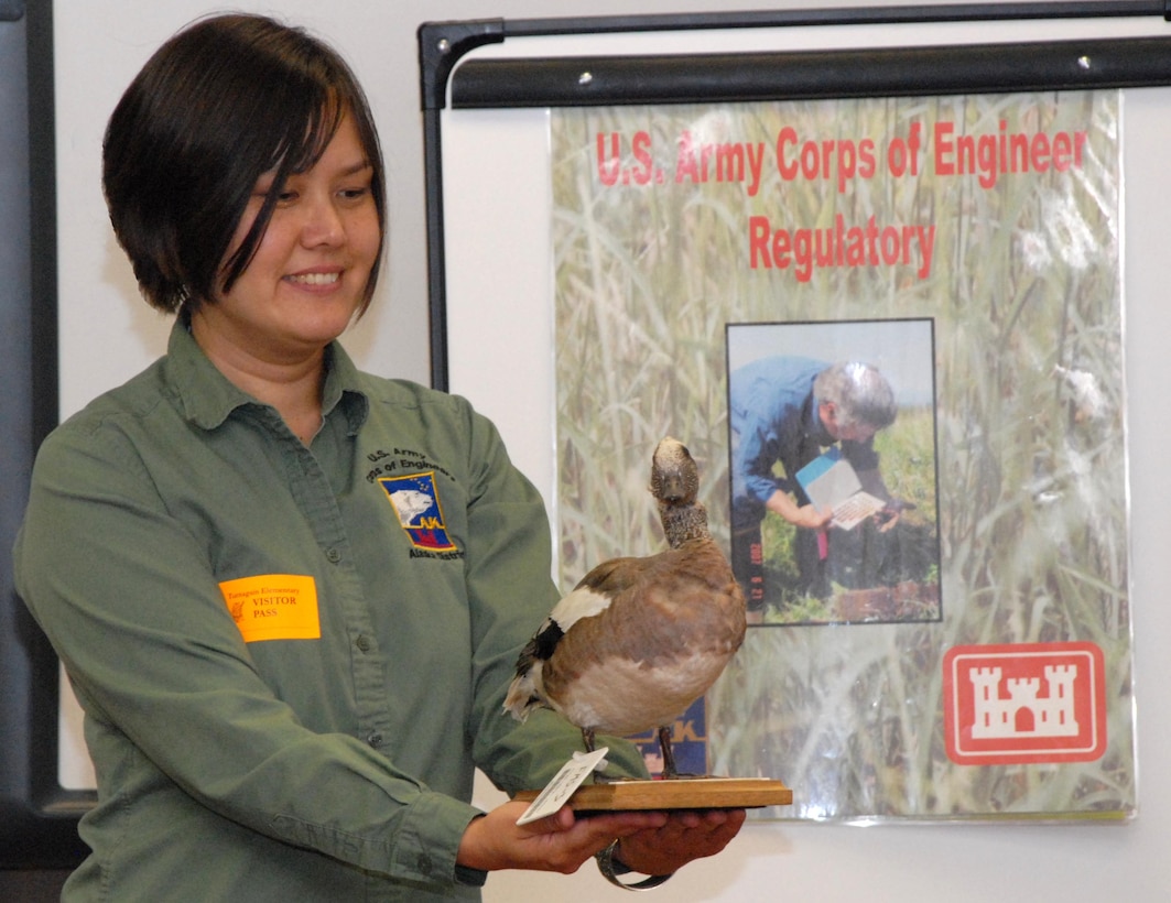 Janet Post, regulatory specialist in the Regulatory Division, shows a taxidermy duck to a group of 5th and 6th graders at Turnagain Elementary School during a STEM outreach event for the Alaska District.