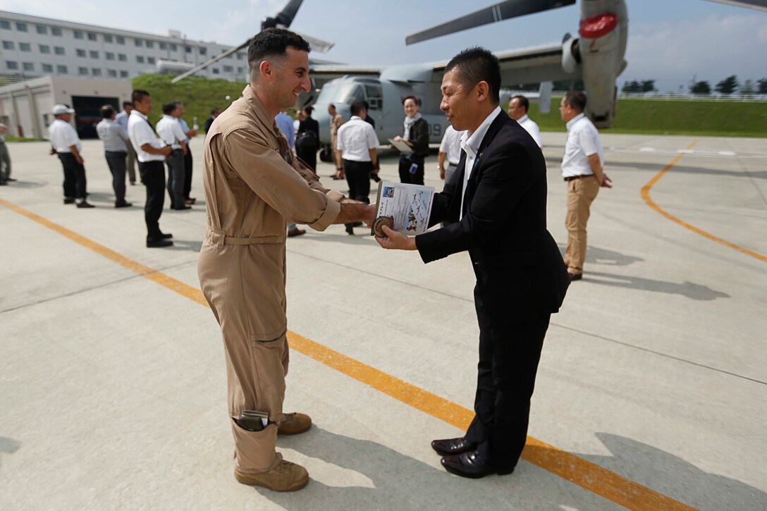 Yohei Wakabayashi (right), Gotenba mayor, receives the Marine Medium Tiltrotor Squadron 265 (VMM-265) patch and coin from U.S. Marine Corps Capt. David Goodman, aircraft commander with Marine VMM-265, Marine Aircraft Group 36, 1st Marine Aircraft Wing, III Marine Expeditionary Force on the Combined Arms Training Center Camp Fuji, Japan, July 15, 2014. The Marines' mission while in the Combined Arms Training Center Camp Fuji was to determine the possibility of future landing zones for the MV22 Osprey. (U.S. Marine Corps photo by MCIPAC Combat Camera Lance Cpl. Luis A. Rodriguez III/ Released)