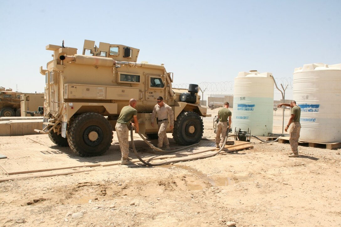 Motor transport Marines with 1st Battalion, 2nd Marine Regiment, prepare to wash a Mine-Resistant Ambush Protected vehicle aboard Camp Leatherneck, Helmand province, Afghanistan, July 11, 2014. All the vehicles are cleaned, inside and out, and then fluids and fuel are drained to a safe level before being retrograded.
