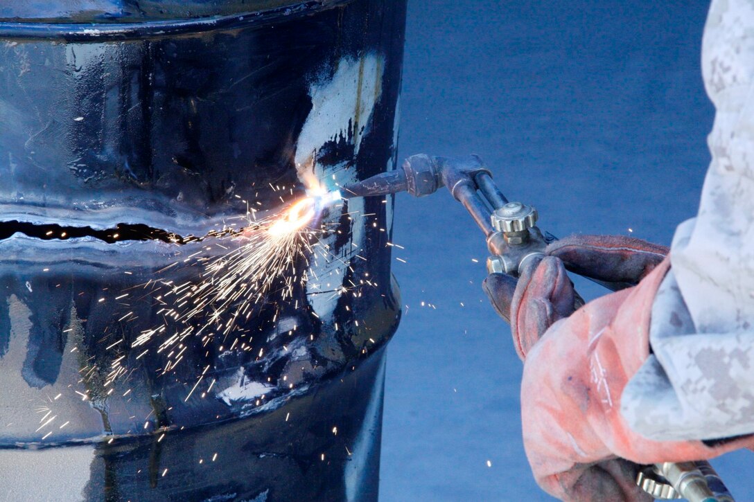 Lance Cpl. Zachary Graybill, a motor transport mechanic with 1st Battalion, 2nd Marine Regiment, welds a metal drum used to store hazardous materials aboard Camp Leatherneck, Helmand province, Afghanistan, July 11, 2014. Graybill, a native of Duncannon, Pennsylvania, is one of the mechanics responsible for ensuring vehicles run properly and effectively in order to complete the mission for coalition forces serving with Regional Command (Southwest).
