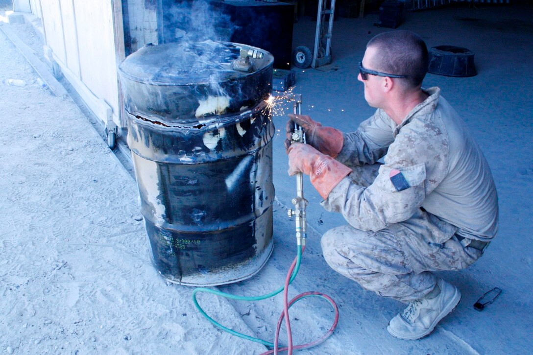 Lance Cpl. Zachary Graybill, a motor transport mechanic with 1st Battalion, 2nd Marine Regiment, welds a metal drum used to store hazardous materials aboard Camp Leatherneck, Helmand province, Afghanistan, July 11, 2014. Graybill, a native of Duncannon, Pennsylvania,  is one of the mechanics responsible for ensuring vehicles run properly and effectively in order to complete the mission for coalition forces serving with Regional Command (Southwest).
