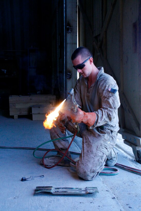 Lance Cpl. Zachary Graybill, a motor transport mechanic with 1st Battalion, 2nd Marine Regiment, prepares to weld a piece of metal aboard Camp Leatherneck, Helmand province, Afghanistan, July 11, 2014. Graybill, a native of Duncannon, Pennsylvania, is one of the mechanics responsible for ensuring vehicles run properly and effectively in order to complete the mission for coalition forces serving with Regional Command (Southwest).