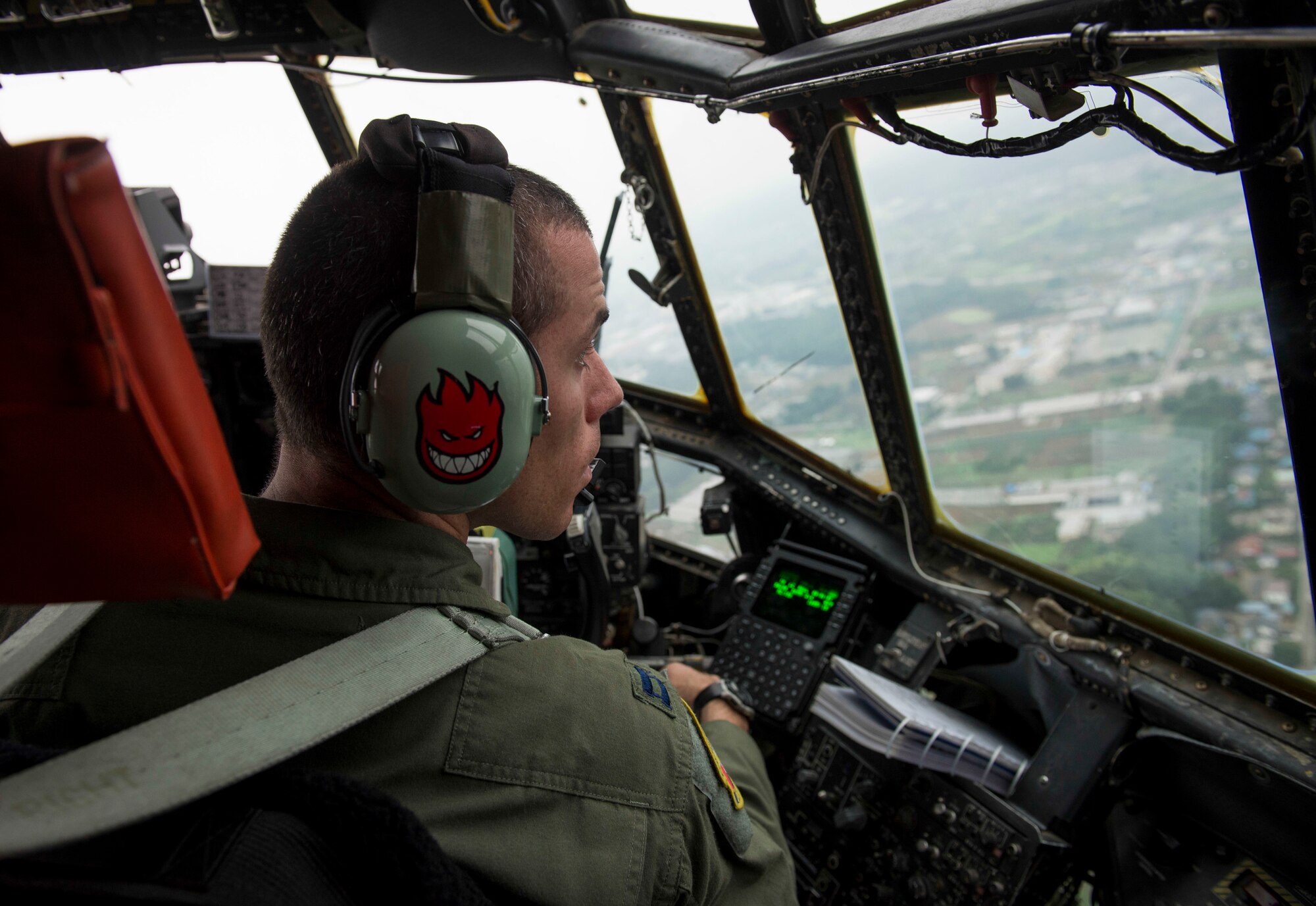 Capt. Matthieu Rigollet, 36th Airlift Squadron C-130 pilot, looks out during a flight at Yokota Air Base, Japan, July 17, 2014.  The C-130 aircrews demonstrated their airlift capabilities during a large formation flight. (U.S. Air Force photo by Airman 1st Class Meagan Schutter/Released)