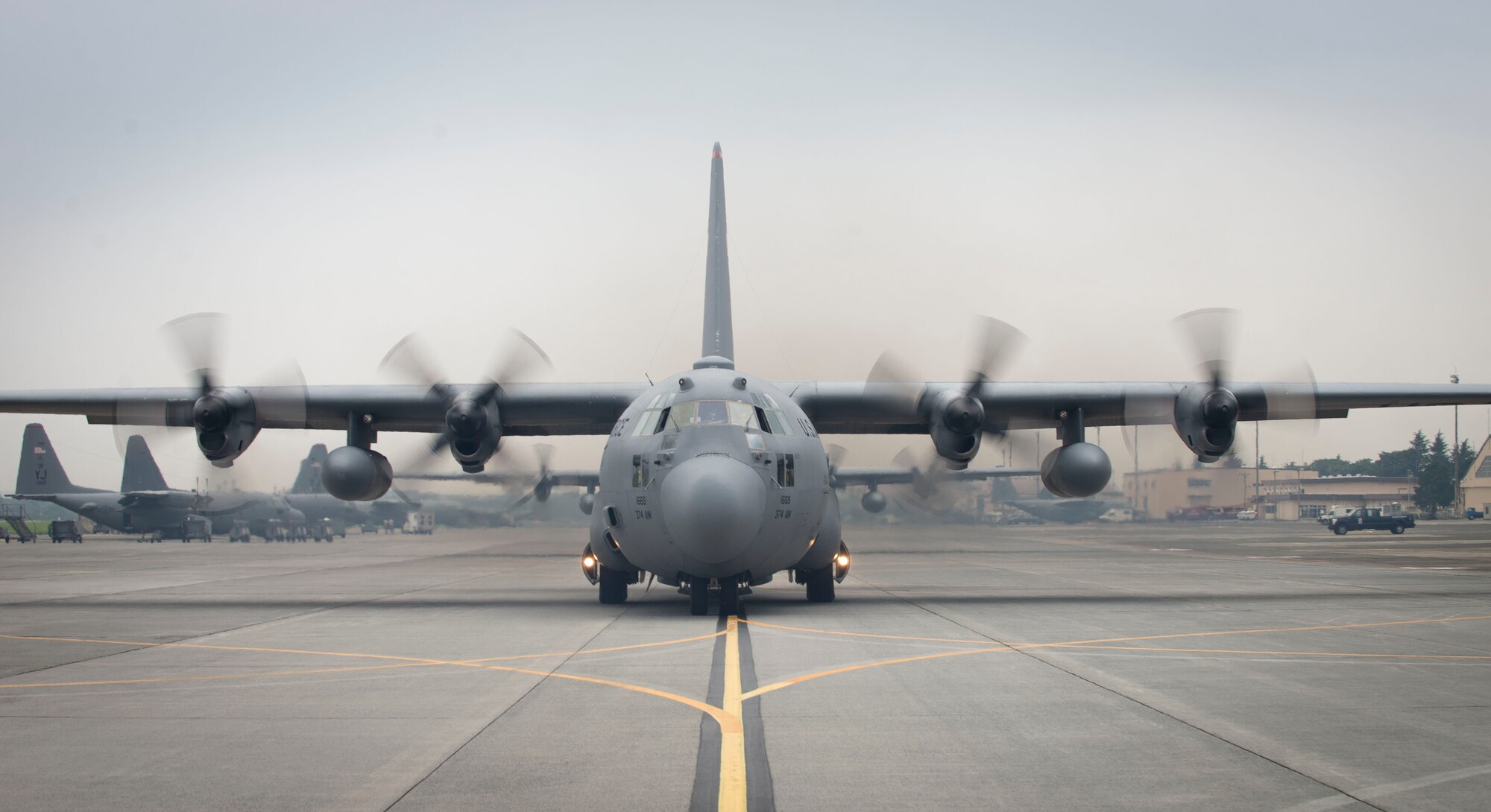 A C-130 Hercules taxis the flight line at Yokota Air Base, Japan, July 17, 2014. A total of six C-130's were generated. Formations such as these help reacquaint pilots with the necessary skills needed during a contingency. (U.S. Air Force photo by Airman 1st Class Meagan Schutter/Released)