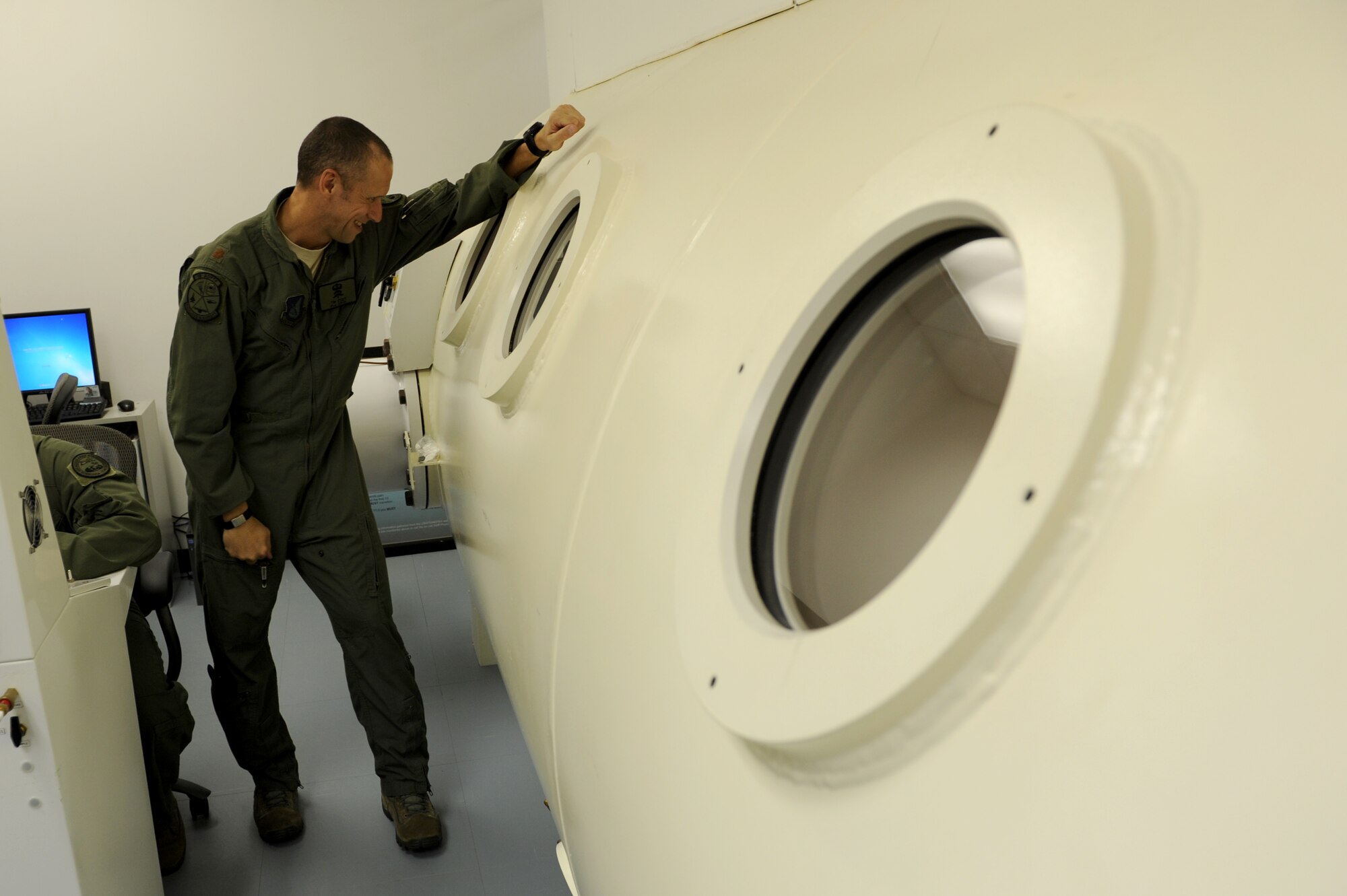 U.S. Air Force Maj. Tim Stout, 18th Aerospace and Operational Physiological Training Flight commander, looks through a porthole to check on service members inside a hyperbaric chamber on Kadena Air Base, Japan, July 17, 2014. This “dive,” which refers to the utilization of the chamber, was the last to take place on Kadena since budget and manning constraints have discontinued use of the chamber. Divers suffering from decompression injury in the future will visit Camp Foster, where they will be assigned an American doctor and taken to be treated in an off-base hyperbaric chamber. (U.S. Air Force photo by Airman 1st Class Zade C. Vadnais)