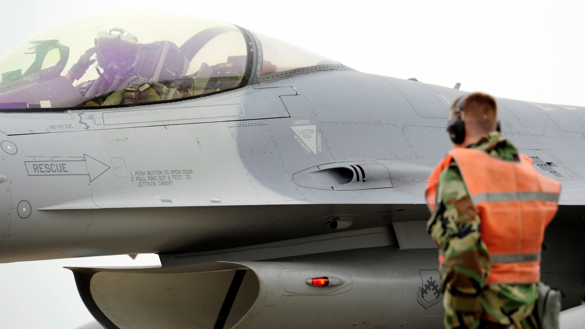 A pilot of an F-16-Fighting Falcon returns a salute to the crew chief before taxiing onto the runway during exercise Beverly Midnight 14-2 at Kunsan Air Base, Republic of Korea, July 16, 2014. The Operational Readiness Exercise assesses mission capabilities and ensures the Wolf Pack is in a constant state of readiness. (U.S. Air Force photo by Senior Airman Taylor Curry/Released) 