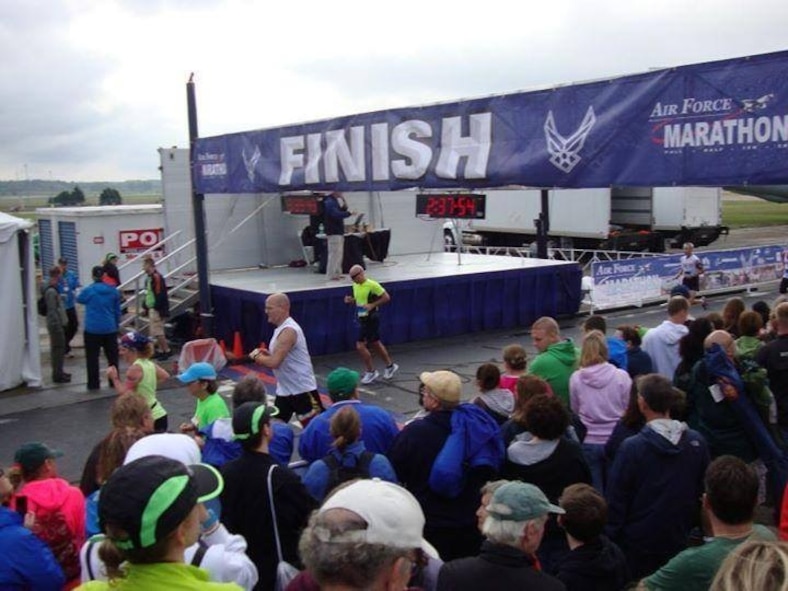 U.S. Air Force Senior Airman Seth Michael, center, 7th Equipment Maintenance Squadron, crosses the finish line at the 2013 Air Force Marathon Sept. 21, 2013, at Wright Patterson Air Force Base, Ohio. Michael finished in the top 10 percent of more than 6,000 runners. (Courtesy photo)