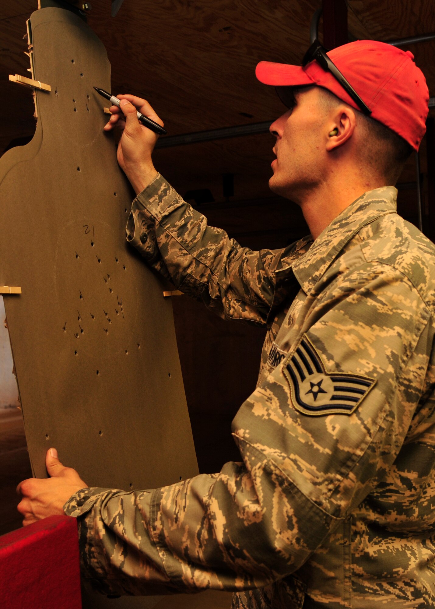 Staff Sgt. Brandon Elderkin, 56th Security Forces Squadron Combat Arms instructor, tallies the number of shots fired in specified areas at the firing range. Students are required to make a minimum of 35 shots on target to become qualified. (U.S. Air Force photo/Senior Airman Grace Lee)