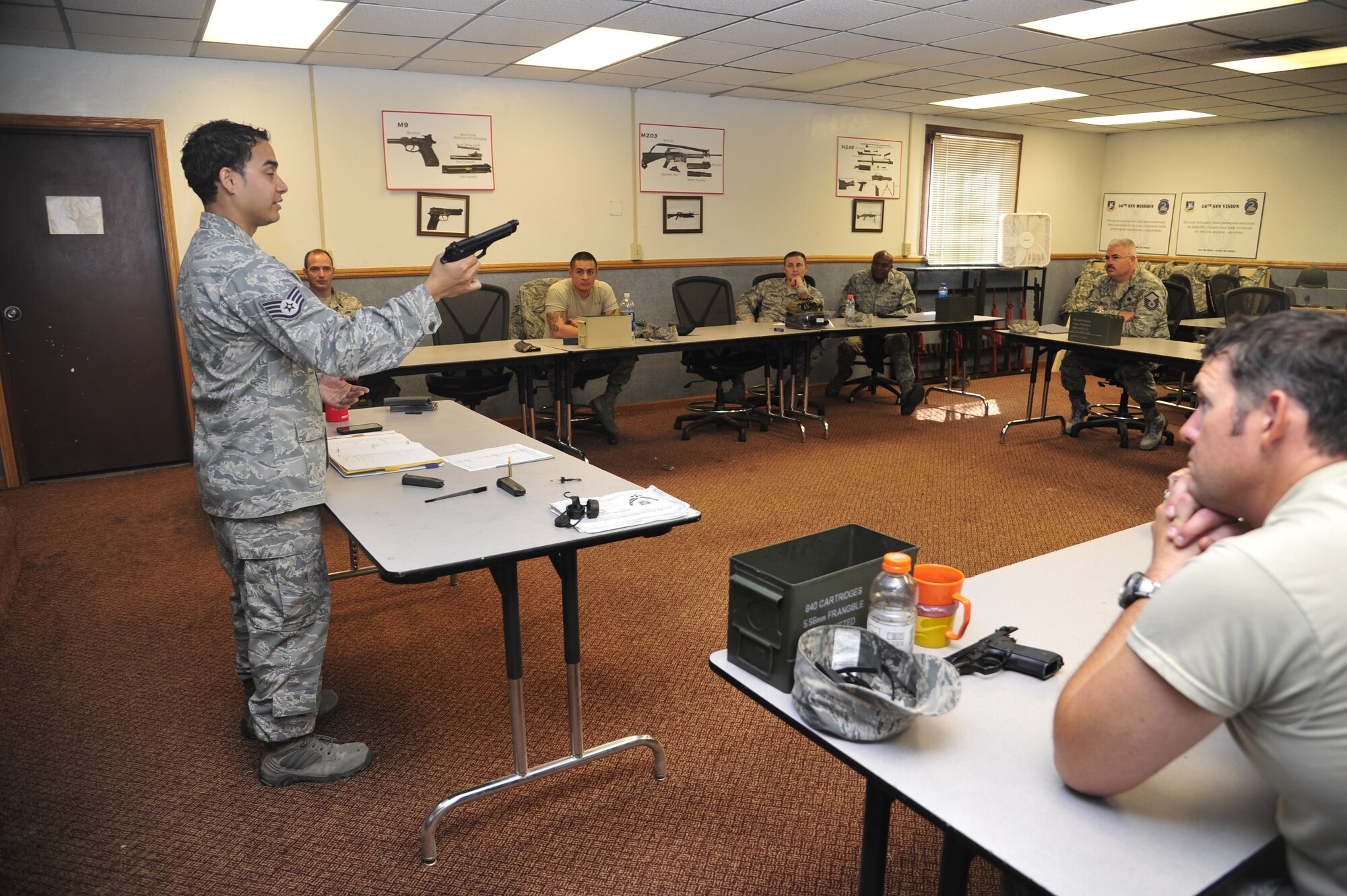 Staff Sgt. Luis Valentin, 56th SFS Combat Arms instructor, shows students how to do a function check on the M9 pistol. A function check must be performed to ensure the weapon has been assembled correctly. (U.S. Air Force photo/Senior Airman Grace Lee)