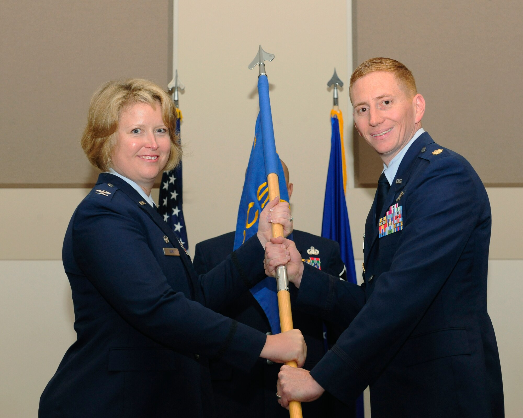 Maj. Christopher Kennedy, 460th Space Communications Squadron commander, right, receives the 460th SCS guidon from Col. DeAnna Burt, 460th Operations Group commander, during the 460th SCS Change of Command ceremony July 17, 2014, at the Leadership Development Center on Buckley Air Force Base, Colo. The event signaled Kennedy’s assumption of command from Lt. Col. Hew Wells. (U.S. Air Force photo by Airman 1st Class Samantha Saulsbury/Released)