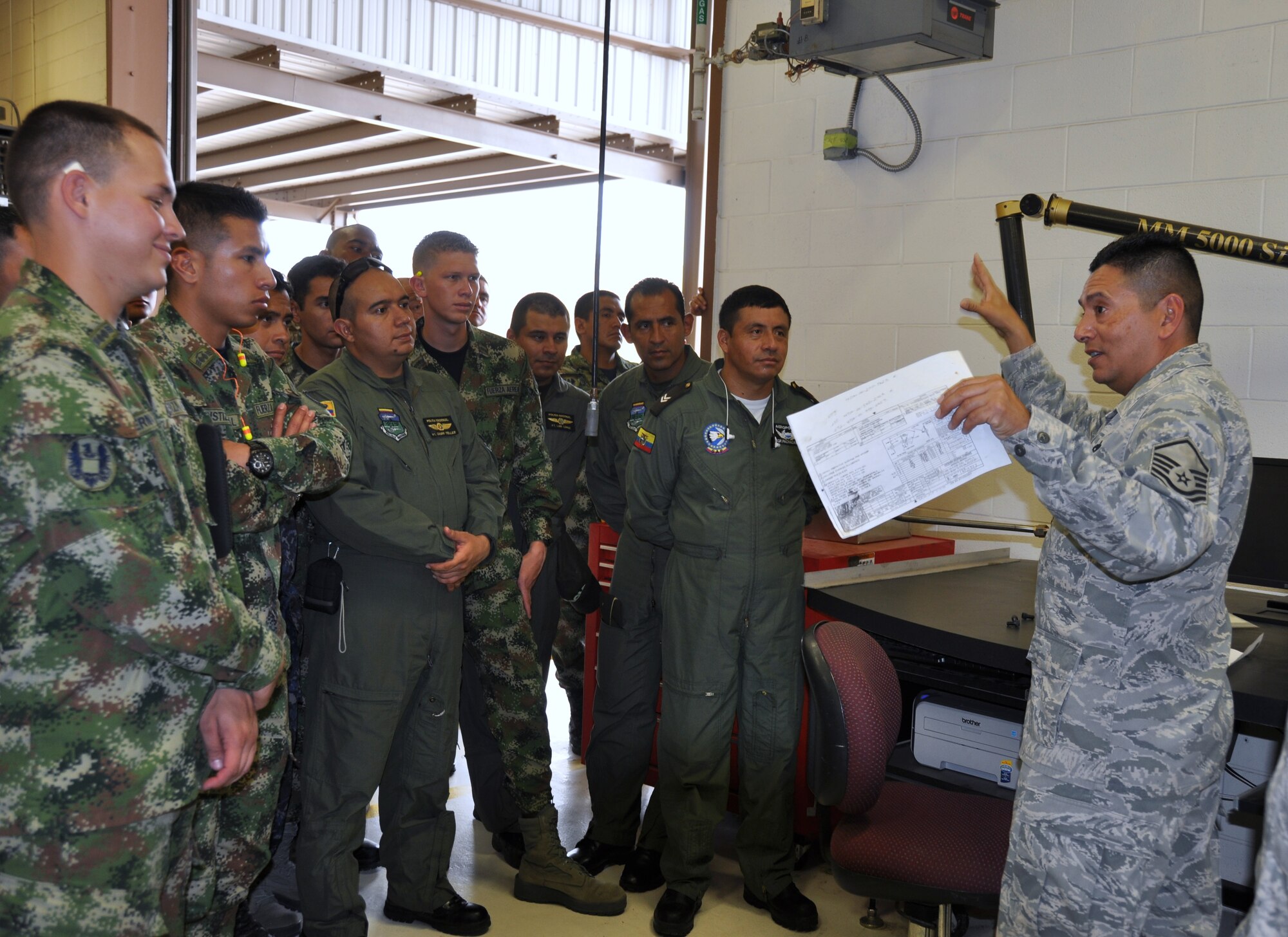 Master Sgt. Max Hernandez, (right) a structural repair technician, 433rd Maintenance Squadron, Joint Base San Antonio-Lackland, Texas explains a blueprint to Inter-American Air Forces Academy students during a tour on July 17, 2014. The students visited the wing's propulsion branch, metals technology and structural repair shops (U.S. Air Force photo by Tech Sgt. Carlos J. Trevino)