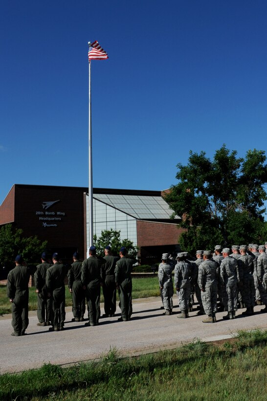 28th Logistics Readiness Squadron personnel salute the flag during a retreat ceremony at Ellsworth Air Force Base, S.D., July 14, 2014. Each month, one squadron on base holds the ceremony at the base flagpole to remember and honor its Air Force heritage. (U.S. Air Force photo by Senior Airman Hailey R. Staker/Released)