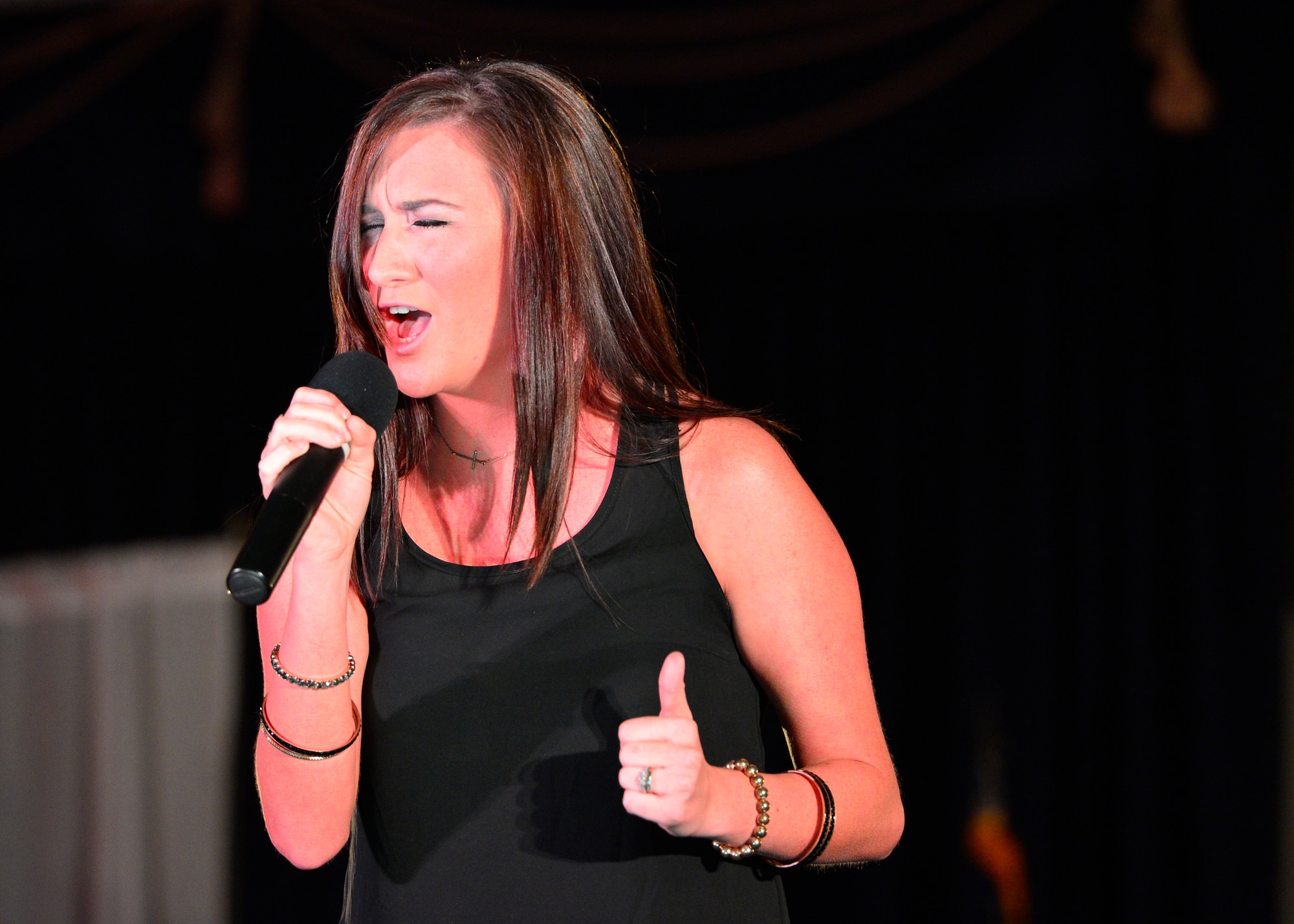 Shannon Garcia, wife of Airman 1st Class Tyler Garcia, 436th Aircraft Maintenance Squadron, sings A Broken Wing by Martina McBride during the Air Mobility Icon competition July 16, 2014, at the Landings Club on Dover Air Force Base, Del. Garcia finished in first place and won $500. (U.S. Air Force photo/Airman 1st Class Zachary Cacicia)