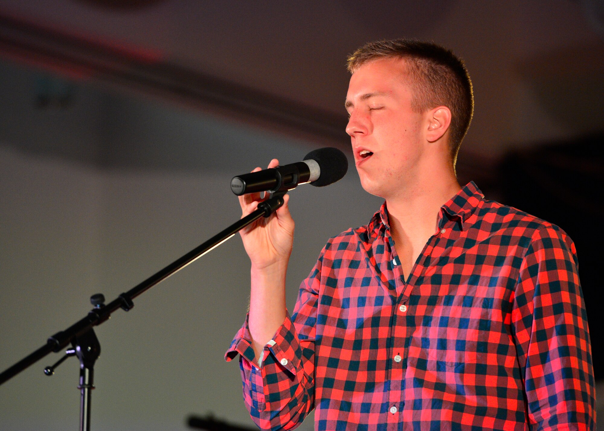 Airman 1st Class Joshua Dinan, 436th Aircraft Maintenance Squadron, sings Awake by Josh Groban during the Air Mobility Icon competition July 16, 2014, at the Landings Club on Dover Air Force Base, Del. Dinan, who came in second place, will represent Team Dover at the command finals. (U.S. Air Force photo/Airman 1st Class Zachary Cacicia)
