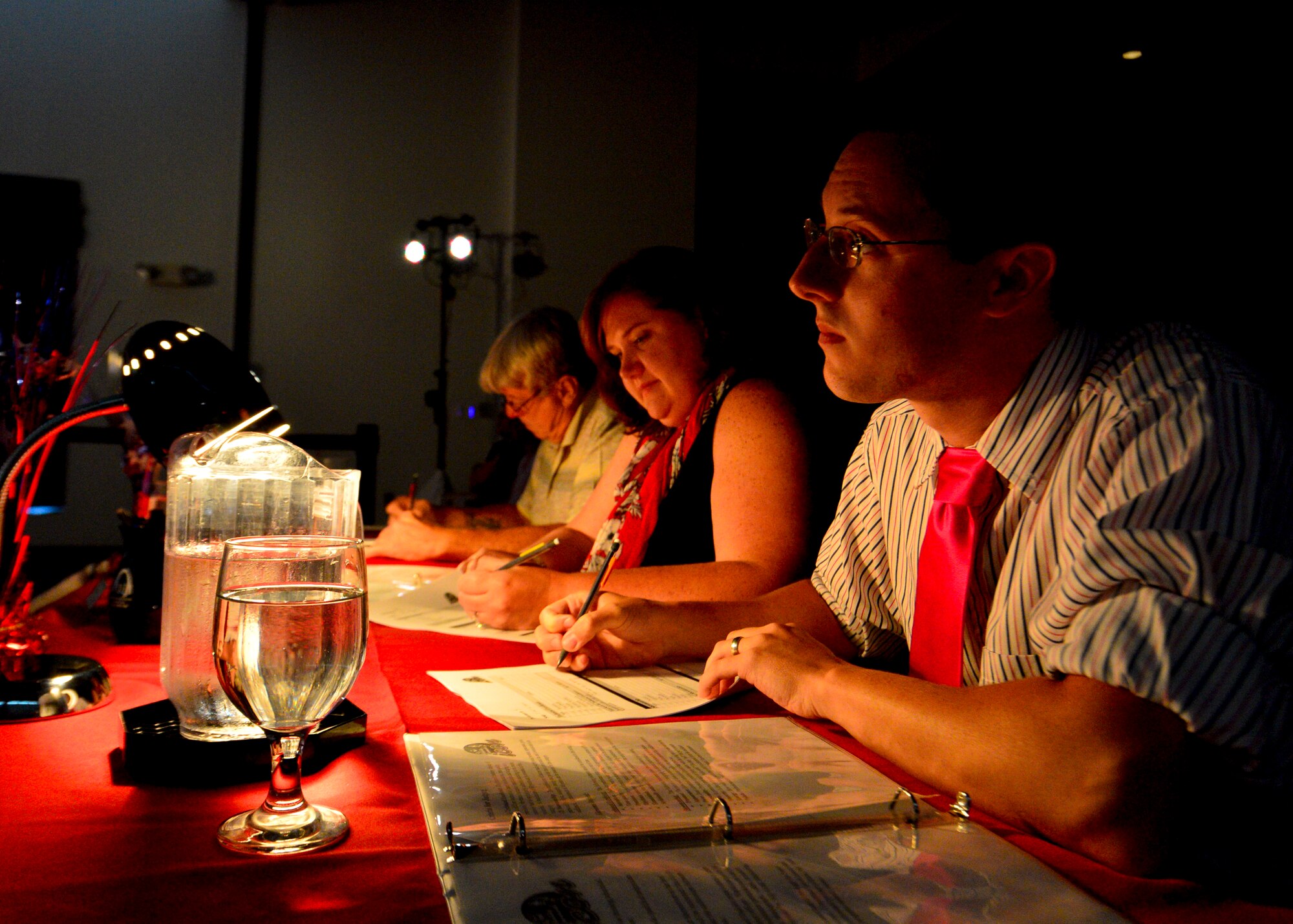 Judges, Chris Patterson, right, Kristin Moore, wife of Col. Rick Moore, 436th Airlift Wing commander, center, and Gary Coleman, evaluate competitors at the Air Mobility Icon competition July 16, 2014, at the Landings Club on Dover Air Force Base, Del. The three person panel judged each singer and selected who will move on to compete at the command finals. (U.S. Air Force photo/Airman 1st Class Zachary Cacicia)