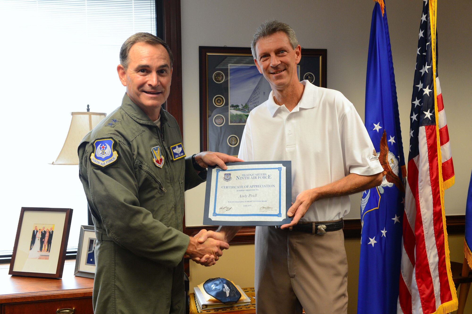 U.S. Air Force Maj. Gen. Jake Polumbo, Ninth Air Force commander, presents
Andy Peidl, 20th Force Support Squadron Carolina Pines Golf Course assistant manager, with a certificate of appreciation at Shaw Air Force Base, S.C., July 15, 2014. During the presentation, Polumbo thanked Peidl, along with Katharine Williams, 20th FSS director of golf, Thad Mertz, 20th FSS golf course superintendant, and Julie Smith20th FSS, restaurant manager, for their innovation, which keeps the golf course running efficiently. Polumbo recognized the team for their hard work and dedication, which has led to an increase in guests and revenue for the course.  (U.S. Air Force photo by Airman 1st Class Jensen Stidham/Released)
