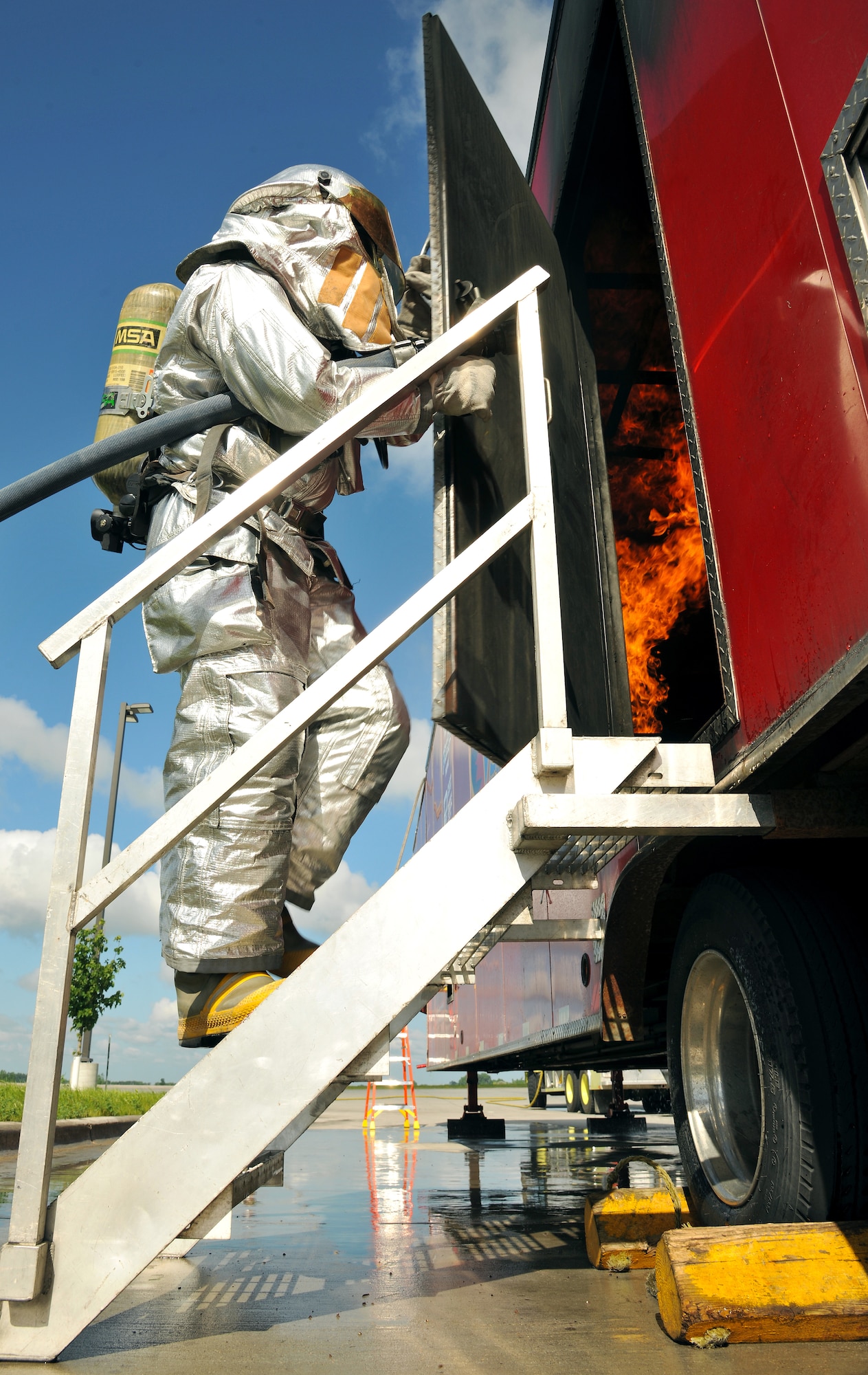 Airman Dustin Mog, 319th Civil Engineer Squadron firefighter, prepares to enter a burn simulator during a training exercise on July 15, 2014, on Grand Forks Air Force Base, N.D. The mobile fire training trailer simulator was equipped with a kitchen and bedroom which were set on fire, testing firefighters’ ability to tame the flames, use proper safety precautions and effective communication. (U.S. Air Force photo/Senior Airman Xavier Navarro)