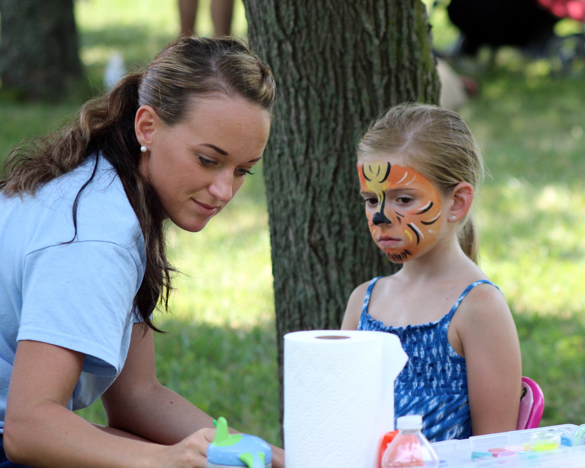 Senior  Airman Shannon Tayfel, a 326th Airlift Squadron member and picnic volunteer, paints a tiger on the face of Faith Riley, the daughter of Tech. Sgt. Thomas Riley, 512th Security Forces Squadron, during the 512th Airlift Wing's Wingman Day Picnic July 12, 2014, at Dover Air Force Base, Del. Other activities for the children included bounce houses and a Youth Fitness Challenge. (U.S. Air Force photo/Staff Sgt. Mercedes Crossland)
