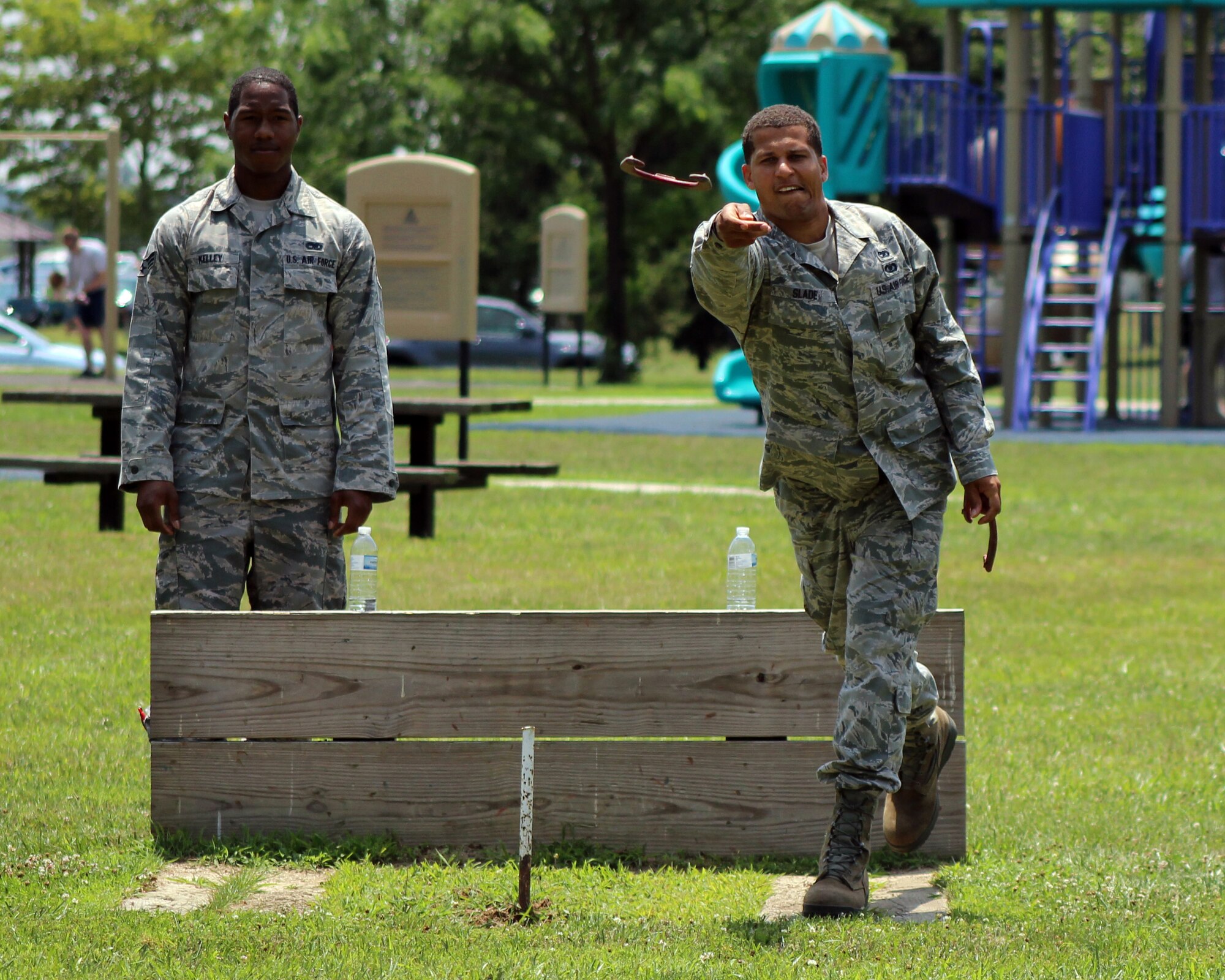 Senior Airman Deon Kelley (left), 712th Aircraft Maintenance Squadron, looks on as Staff Sgt. William Slade, 712th AMXS, throws a horse shoe during the 512th Airlift Wing's Wingman Day Picnic July 12, 2014, at Dover Air Force Base, Del. Other activities included an ultimate fitness challenge, which featured contests in sit-ups, push-ups, tire flips, tug-of-wars and weighted sandbags. (U.S. Air Force photo/Staff Sgt. Mercedes Crossland)