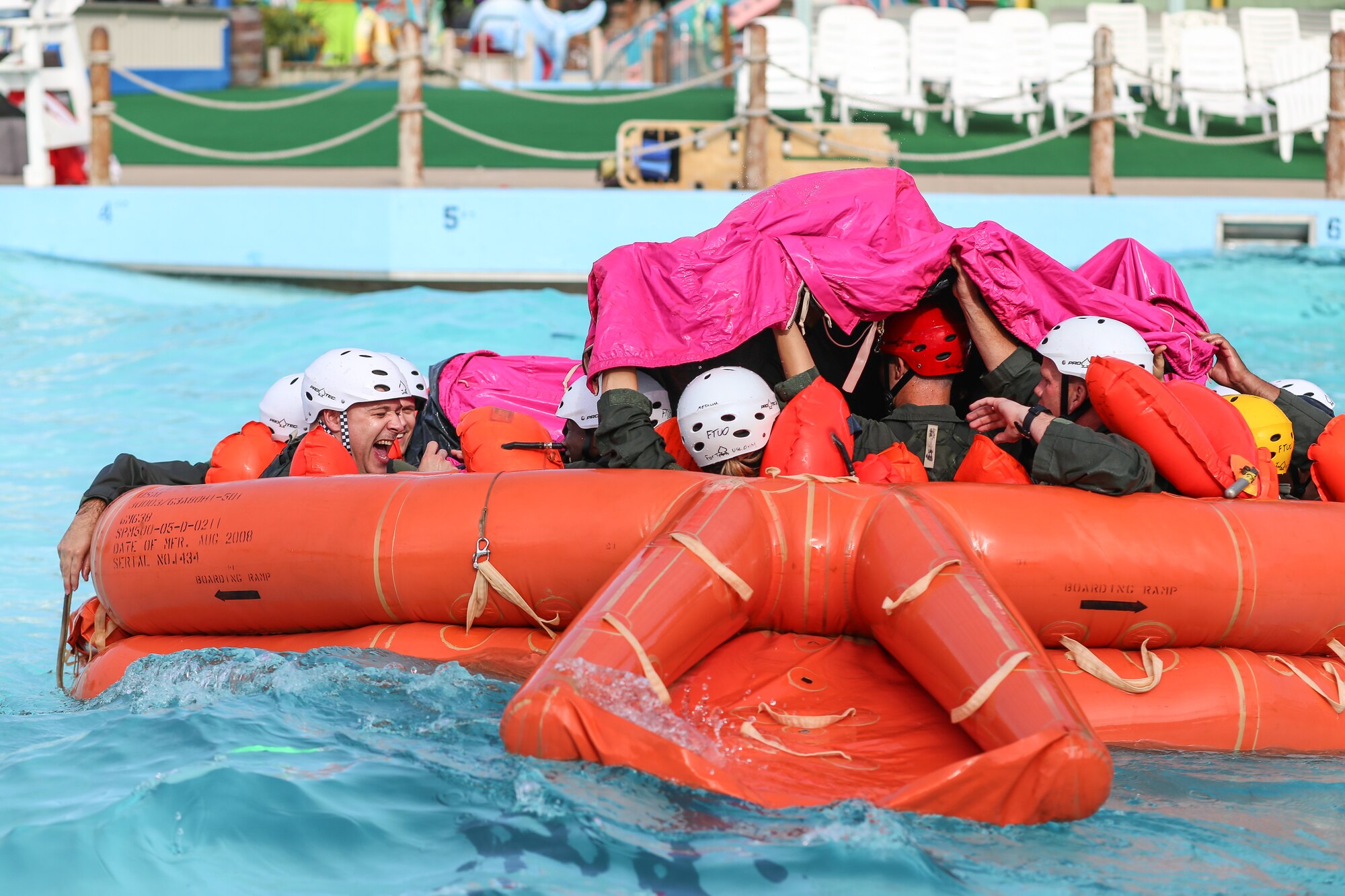 Reservists from the 513th Air Control Group work as a team to pull a canopy over their life raft July 13 at White Water Bay in Oklahoma City. Airmen are taught to use the tarp to prevent large waves from filling the raft. (U.S. Air Force photo/Staff Sgt. Caleb Wanzer)