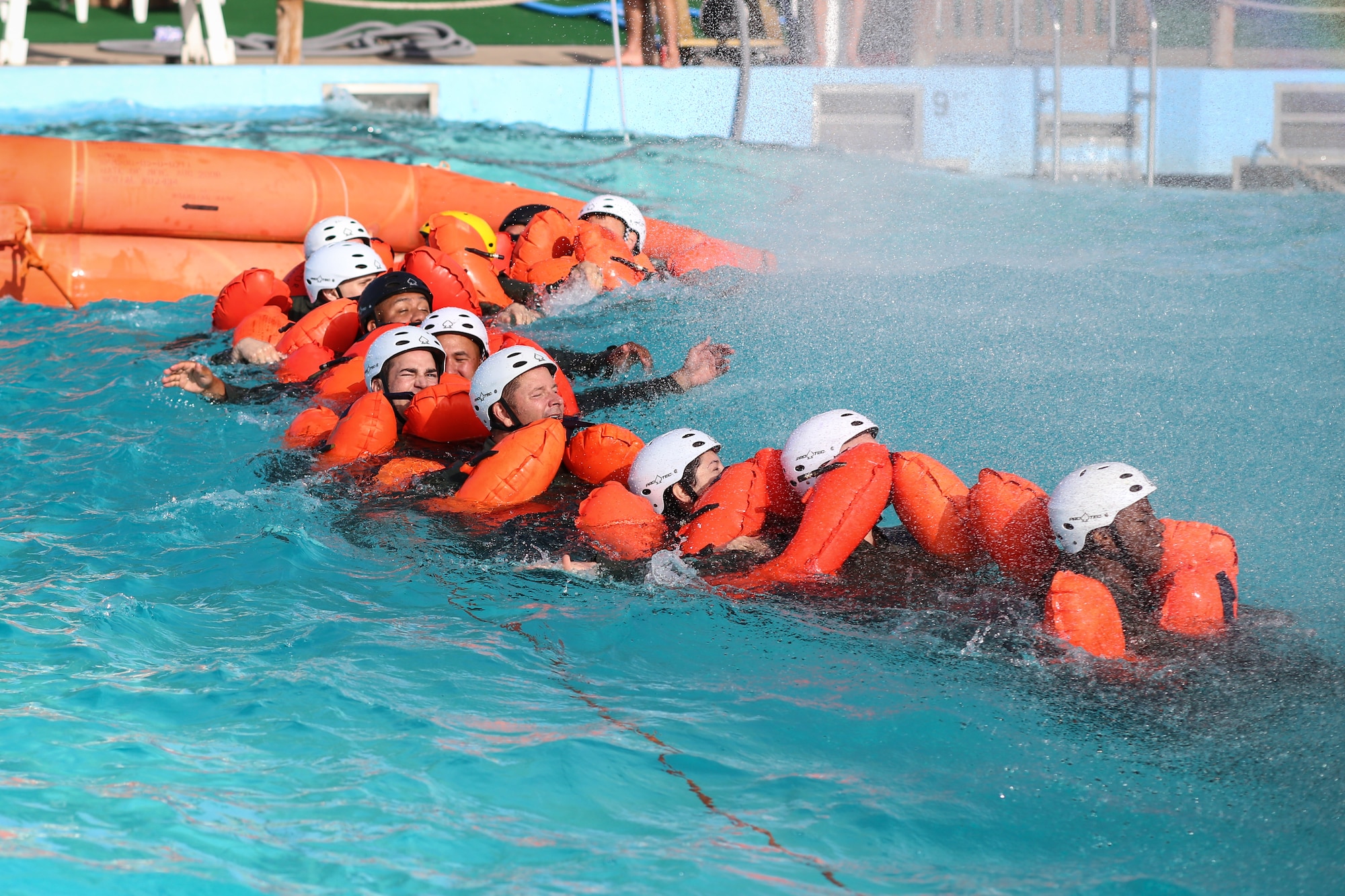 Airmen from the 513th Air Control Group chain up on their way to the life raft during water survival training July 13 at White Water Bay in Oklahoma City. Chaining up prevents any crew members from separating after ditching the aircraft. (U.S. Air Force photo/Staff Sgt. Caleb Wanzer)