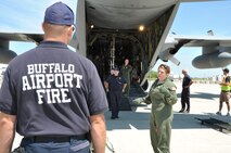 Staff Sgt. Hilary Drogus, 911th Airlift Wing Aeromedical Evacuation Technician, directs Buffalo Niagara International Fire Fighters on proper litter carrying techniques from plane to runway at the Buffalo Niagara International Airport, July 12, 2014 as part of the National Disaster Medical System exercise held at the 911th AW.