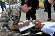 Tech. Sgt. Audra Cubbage, 911th Aeromedical Staging Squadron health services manager, documents a simulated patient’s symptoms before being transported to the patient triage area during Lycoming Reach, a National Disaster Medical System exercise, July 12, 2014 at the Pittsburgh IAP ARS, Pa. (U.S. Air Force photo by Senior Airman Joshua J. Seybert)