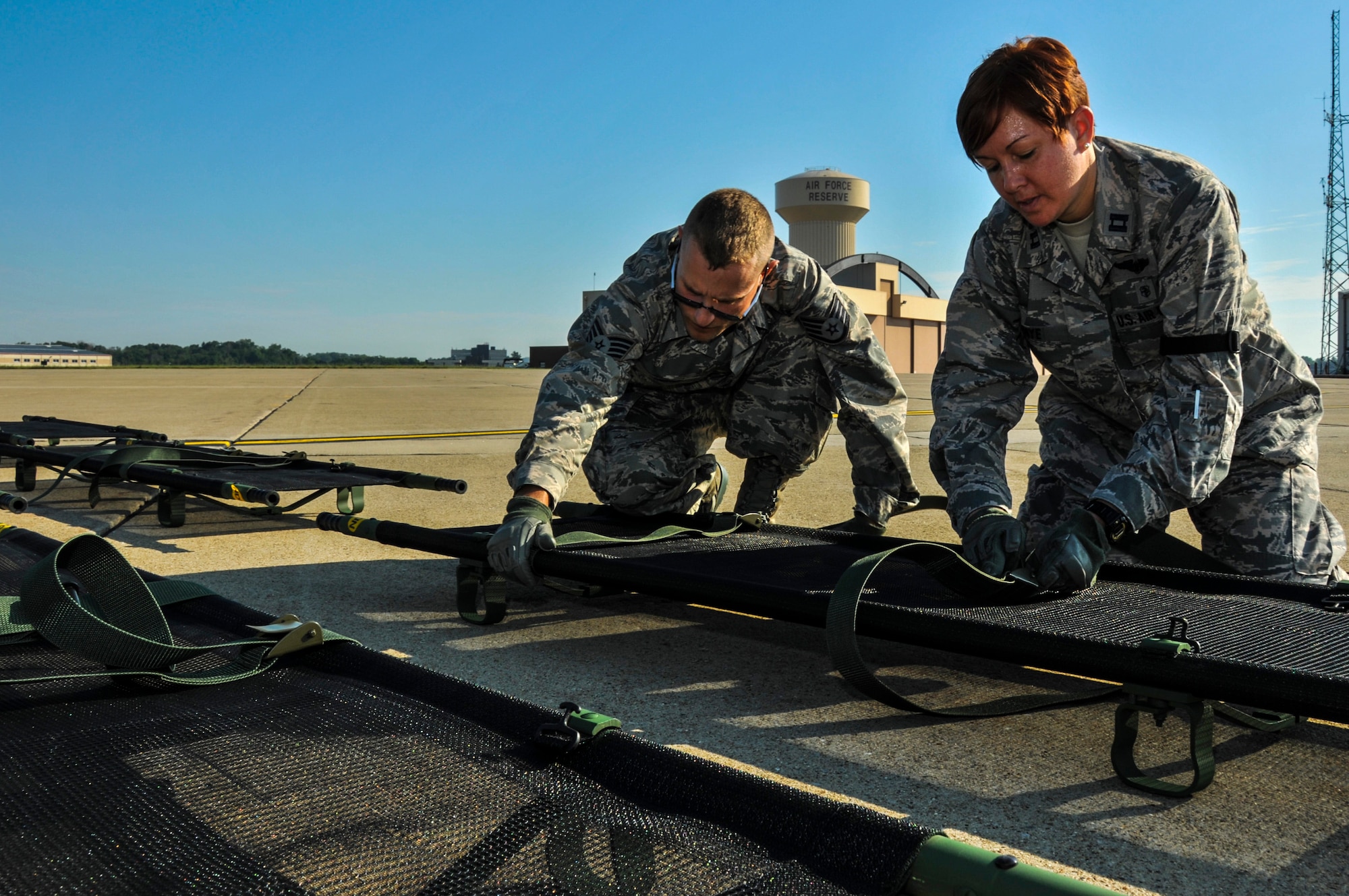 Capt. Bobbi Jo Nye, 911th Aeromedical Evacuation Squadron officer in charge of medical readiness, and Staff Sgt. William Kobily, 911 AES medical logistics specialist, prepare litters for simulated patients during exercise Lycoming Reach, July 12, 2014 at the Pittsburgh IAP/ARS, PA. (U.S. Air Force photo by Senior Airman Joshua J. Seybert)