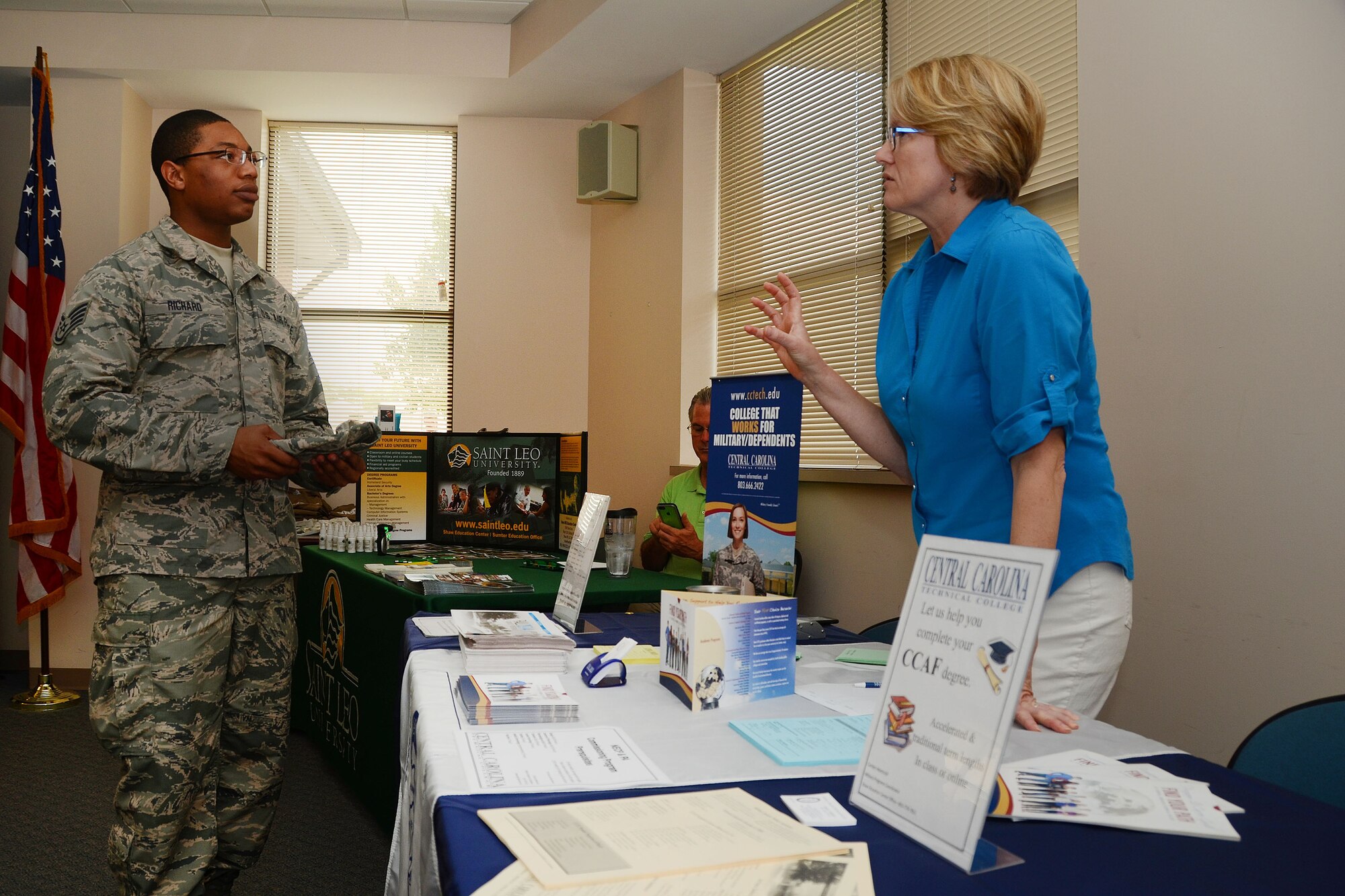 U.S. Air Force Staff Sgt. Eric Richard, assigned to the 169th Fighter Wing, receives education information from Carolyn Adamczyk, a military programs coordinator for Central Carolina Technical College at an education fair on McEntire Joint National Guard Base, S.C. July 12, 2014.  The 169th Fighter Wing sponsored the education fair to encourage Airmen to progress with their technical degree.   (U.S. Air National Guard photo by Airman 1st Class Ashleigh S. Pavelek/Released)