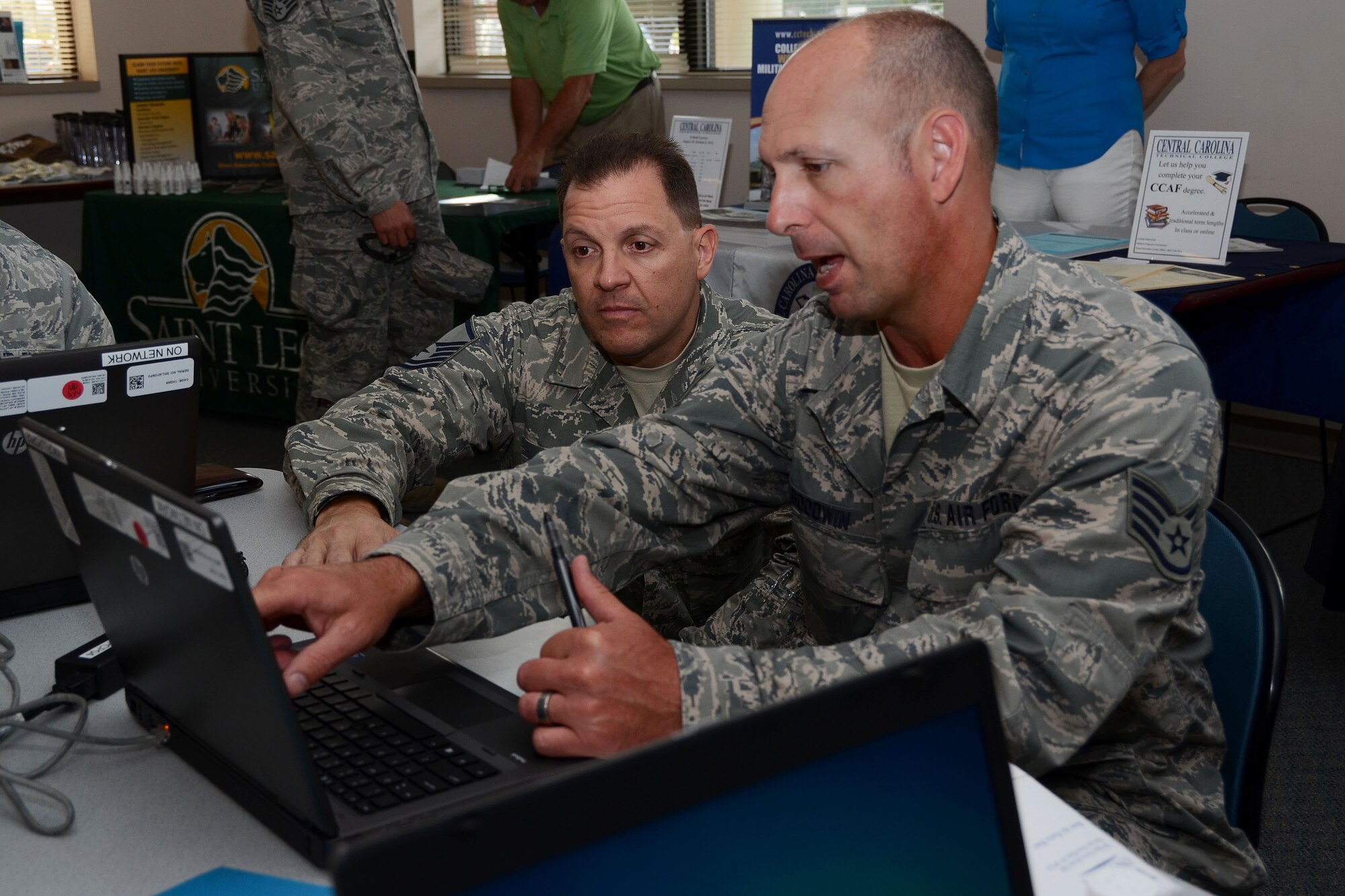 U.S. Air Force Master Sgt. Derek Lacy, assigned to the Community College of the Air Force, assists Staff Sgt. Tony Goodwin, assigned to the 169th Fighter Wing, in updating his CCAF education level during an education fair on McEntire Joint National Guard Base, S.C. July 12, 2014.  Lacy is promoting the National Guard Bureau's Airmen Development Program and encouraging Airmen to progress with their technical degree.  (U.S. Air National Guard photo by Airman 1st Class Ashleigh S. Pavelek/Released)