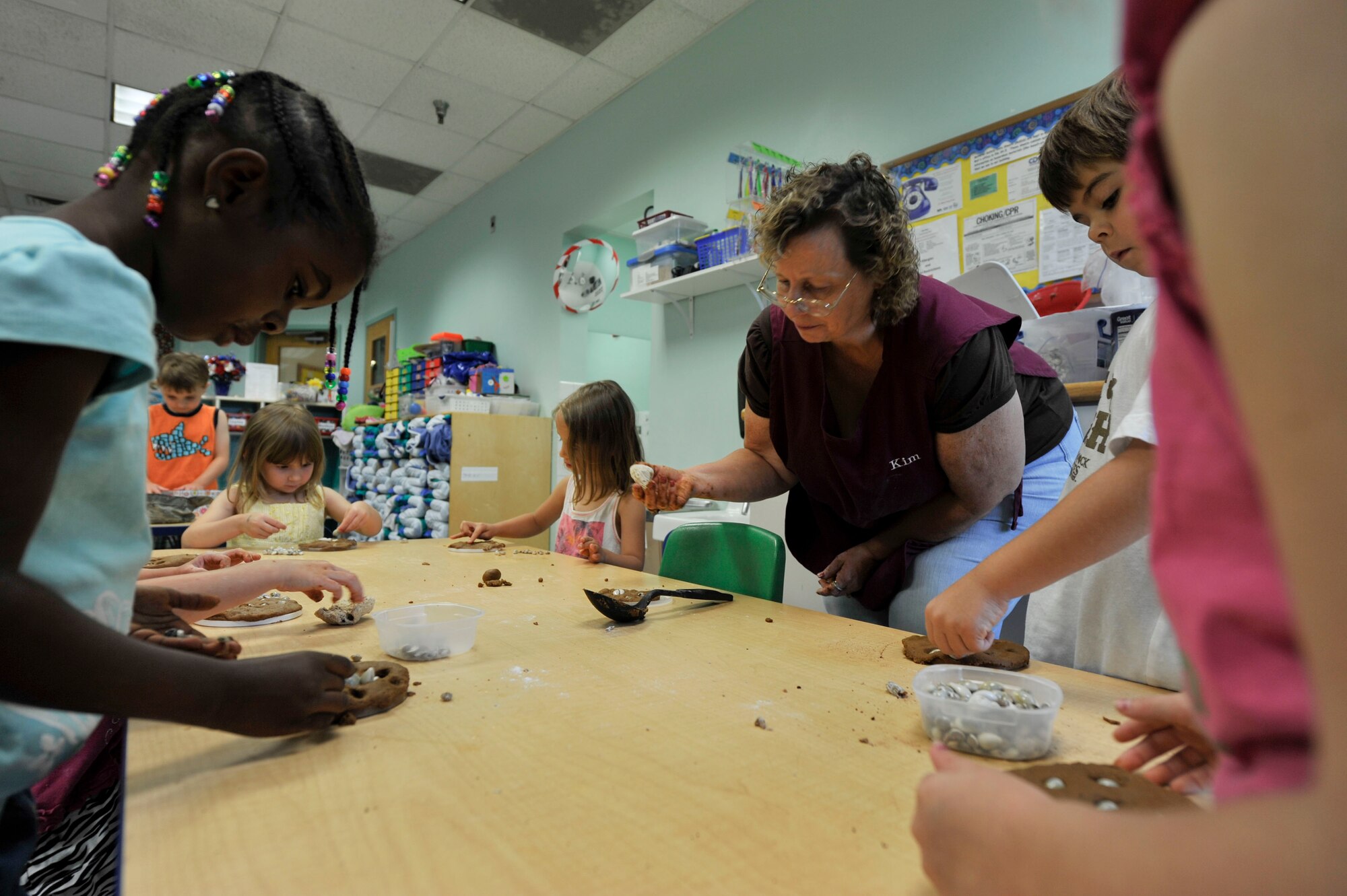 A class of 3 to 5-year-olds from a Child Development Center at Little Rock Air Force Base, uses old plastic container tops and cooking items to create fossils July 8, 2014. Allen’s class has used numerous recycled items to make projects and gifts for their parents. 